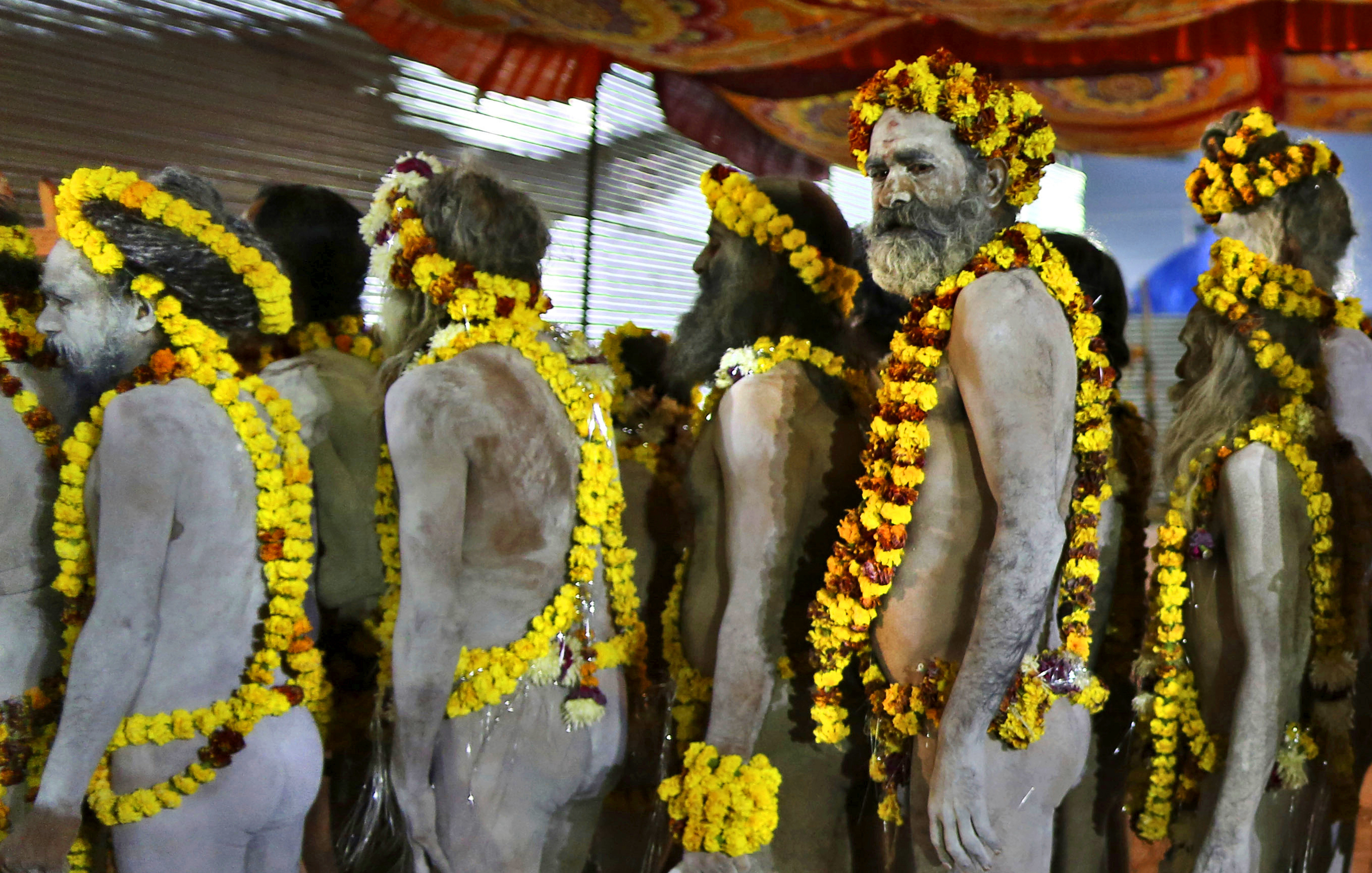 Naked Hindu holy men leave their camp for ritualistic dip on auspicious Makar Sankranti day during the Kumbh Mela, or pitcher festival in Prayagraj, Uttar Pradesh state, India, Tuesday, Jan.15, 2019. The Kumbh Mela is a series of ritual baths by Hindu holy men, and other pilgrims at the confluence of three sacred rivers — the Yamuna, the Ganges and the mythical Saraswati — that dates back to at least medieval times. The city’s Mughal-era name Allahabad was recently changed to Prayagraj. (AP Photo/Rajesh Kumar Singh)