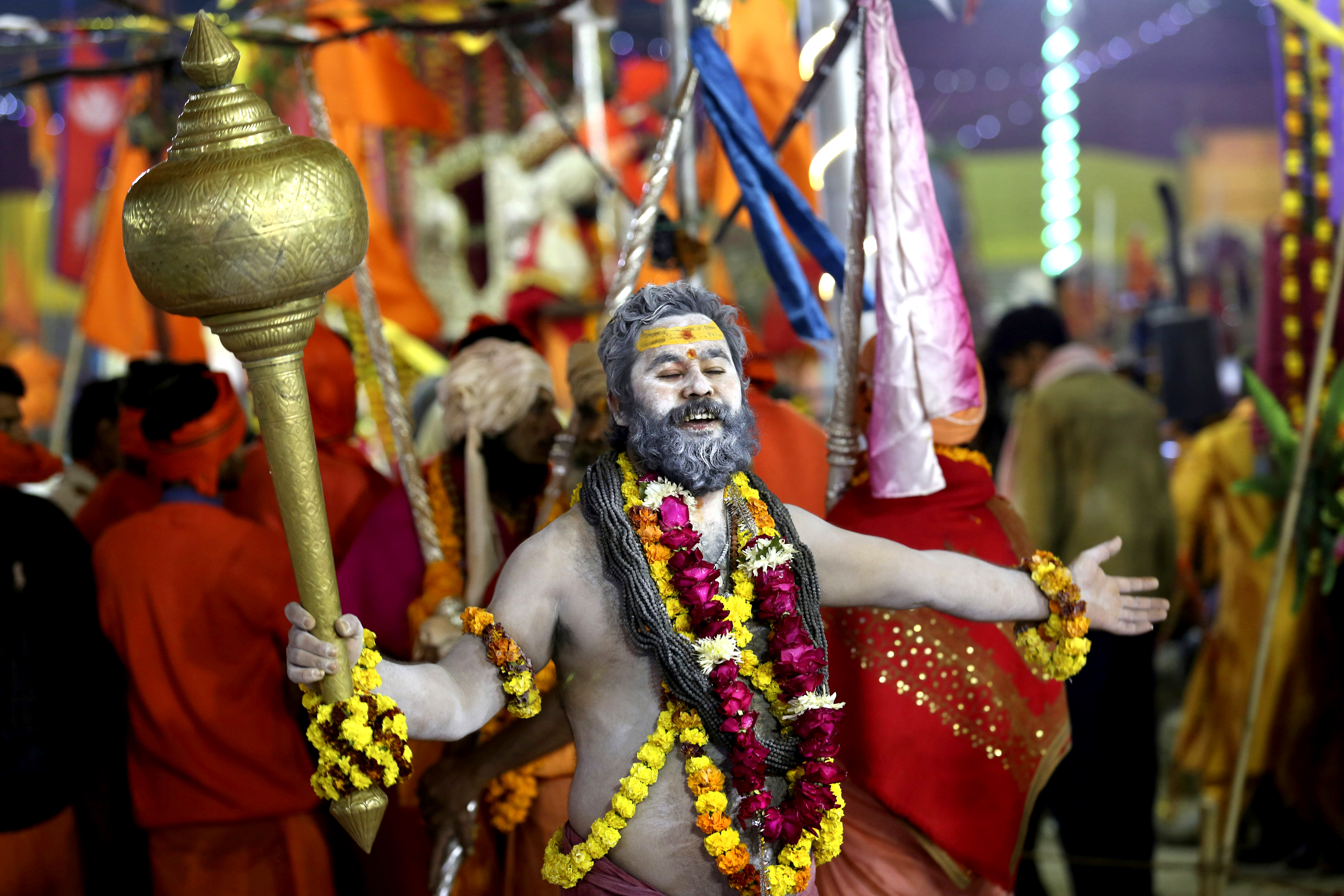 A Hindu holy man dances holding a mace as he arrives for a ritualistic dip on auspicious Makar Sankranti day during the Kumbh Mela, or pitcher festival in Prayagraj, Uttar Pradesh state, India, Tuesday, Jan.15, 2019. The Kumbh Mela is a series of ritual baths by Hindu holy men, and other pilgrims at the confluence of three sacred rivers — the Yamuna, the Ganges and the mythical Saraswati — that dates back to at least medieval times. The city’s Mughal-era name Allahabad was recently changed to Prayagraj. (AP Photo/Rajesh Kumar Singh)