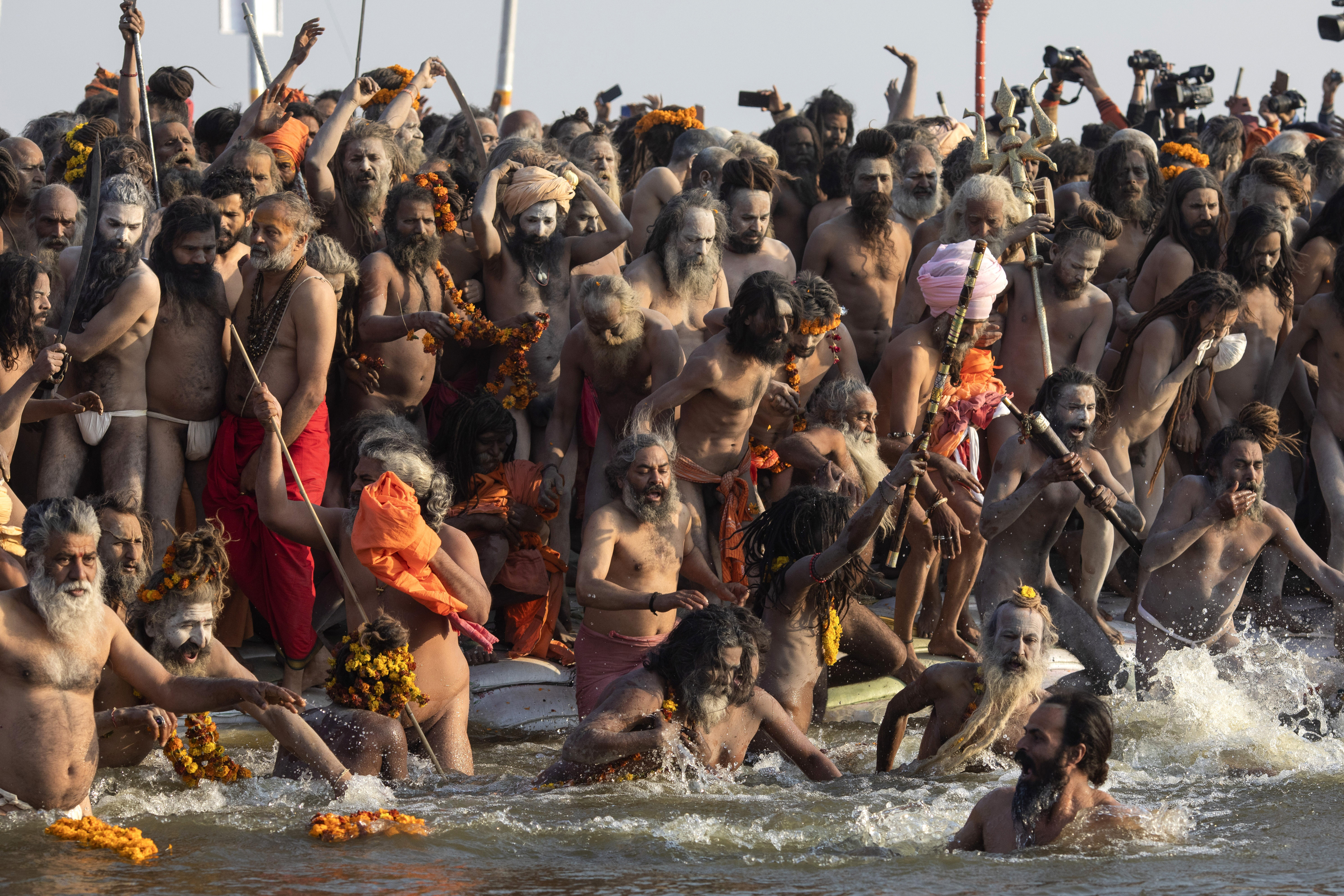 Hindu holy men take a dip on auspicious Makar Sankranti day during the Kumbh Mela, or pitcher festival in Prayagraj, Uttar Pradesh state, India, Tuesday, Jan.15, 2019. The Kumbh Mela is a series of ritual baths by Hindu holy men, and other pilgrims at the confluence of three sacred rivers the Yamuna, the Ganges and the mythical Saraswati  that dates back to at least medieval times. The city's Mughal-era name Allahabad was recently changed to Prayagraj. (AP Photo/Bernat Armangue)