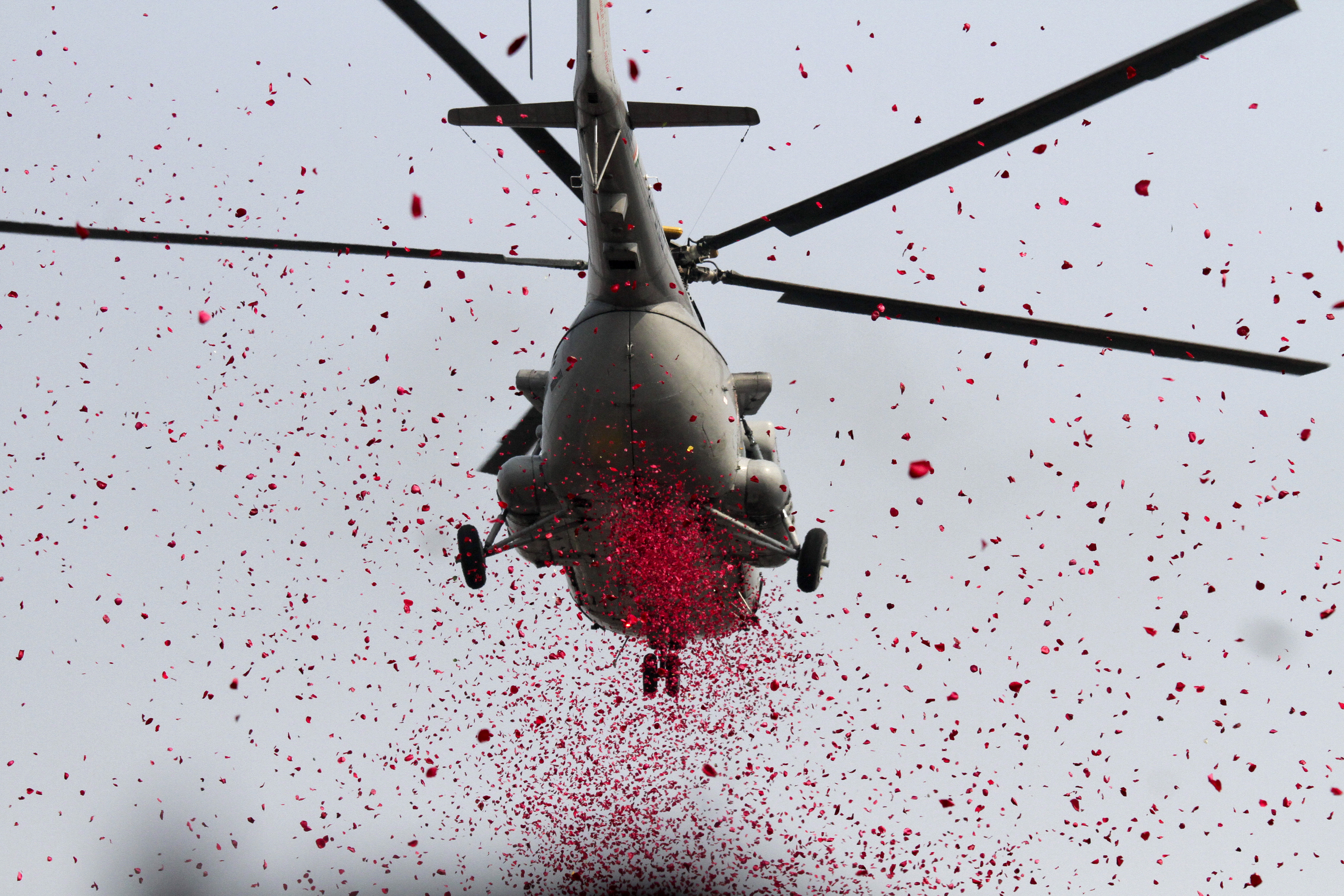 An Indian army helicopter showers flower petals over the Republic Day parade venue in Kolkata, India, Saturday, Jan. 26, 2019. India marks Republic Day on Jan. 26 with military parades across the country. (AP Photo/Bikas Das)