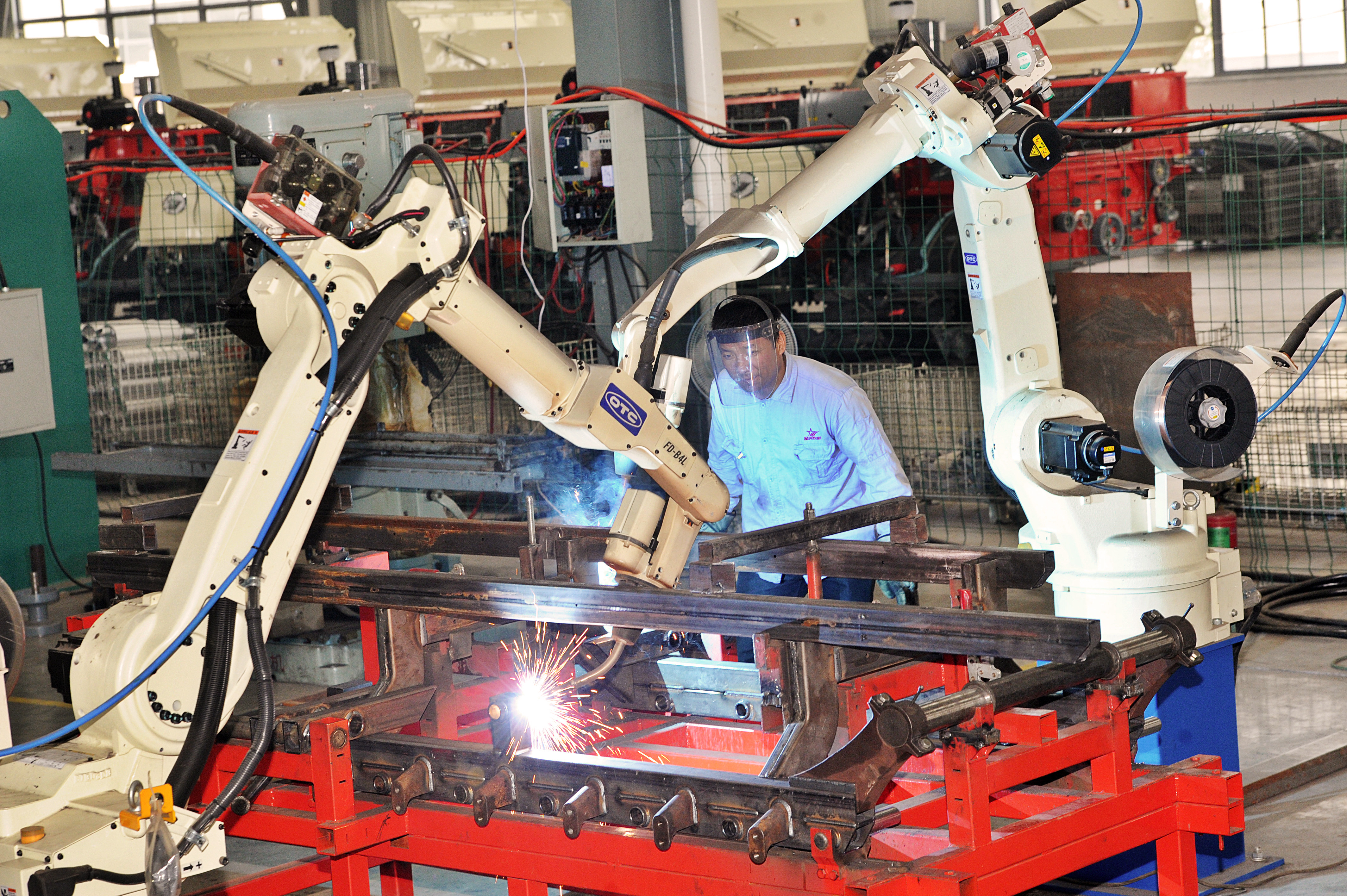 --FILE--A Chinese worker monitors robot arms welding components of reaping machines at the plant of Xingguang Agricultural Machinery Co., Ltd. in Huzhou city, east China's Zhejiang province, 21 October 2014.

China will have more robots operating in its production plants by 2017 than any other country as it cranks up automation of its car and electronics factories, the International Federation of Robotics (IFR) said on Thursday (5 February 2015). Already the biggest market in the $9.5 billion global robot trade, or $29 billion including associated software, peripherals and systems engineering, China lags far behind its more industrialized peers in terms of robot density. China has just 30 robots per 10,000 workers employed in manufacturing industries, compared with 437 in South Korea, 323 in Japan, 282 in Germany and 152 in the United States. But a race by carmakers to build plants in China along with wage inflation that has eroded the competitiveness of Chinese labour will push the operational stock of industrial robots to more than double to 428,000 by 2017, the IFR estimates.