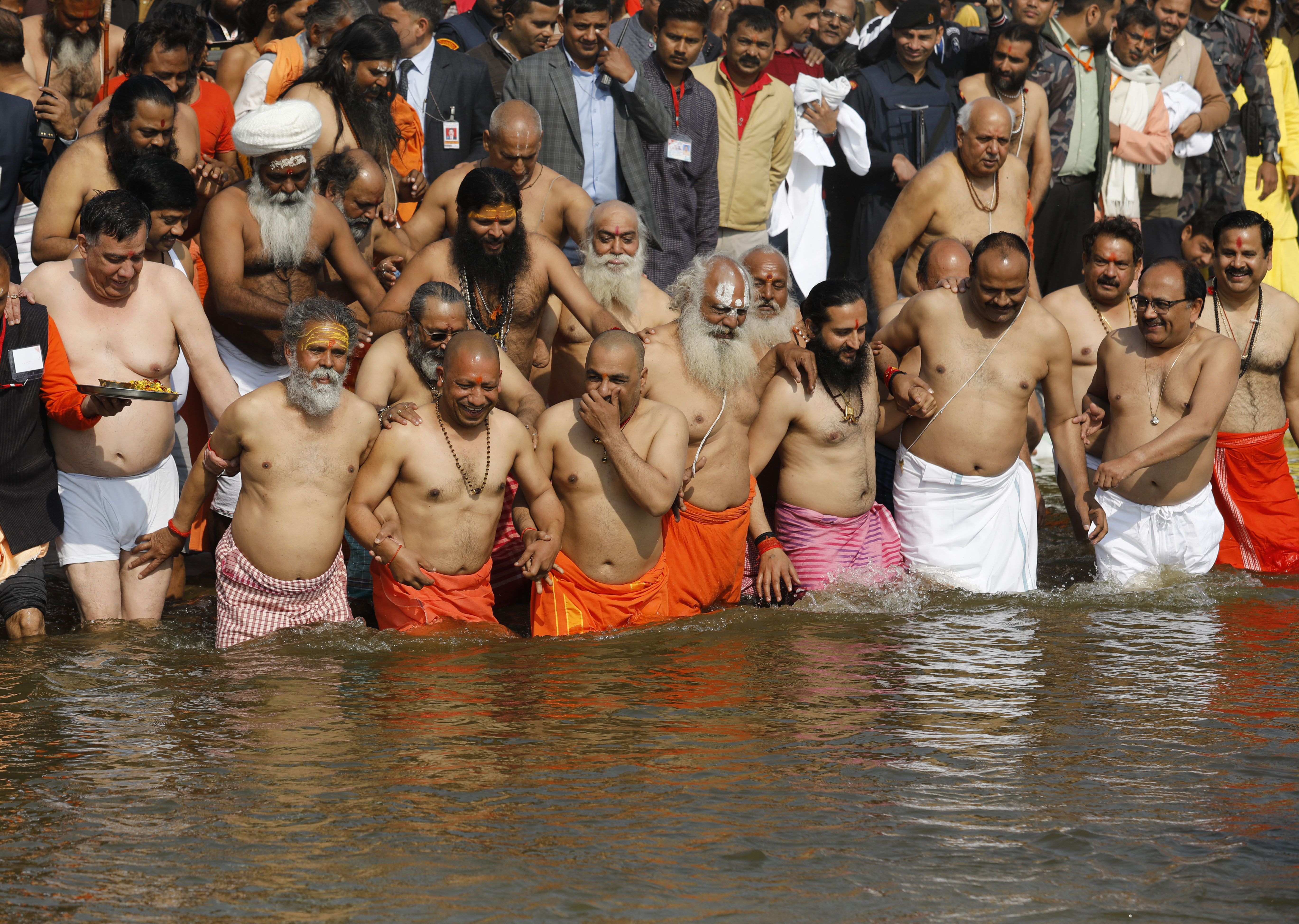 Chief Minister of Uttar Pradesh state Yogi Adityanath, front second left, takes a holy dip accompanied by saints and cabinet colleagues at the Sangam, the confluence of rivers Ganges and Yamuna, during the Kumbh Mela in Prayagraj, India, Tuesday, Jan. 29, 2019. The Kumbh Mela is a series of ritual baths by Hindu holy men, and other pilgrims at the confluence of three sacred rivers the Yamuna, the Ganges and the mythical Saraswati that dates back to at least medieval times. The city's Mughal-era name Allahabad was recently changed to Prayagraj. (AP Photo/Rajesh Kumar Singh)