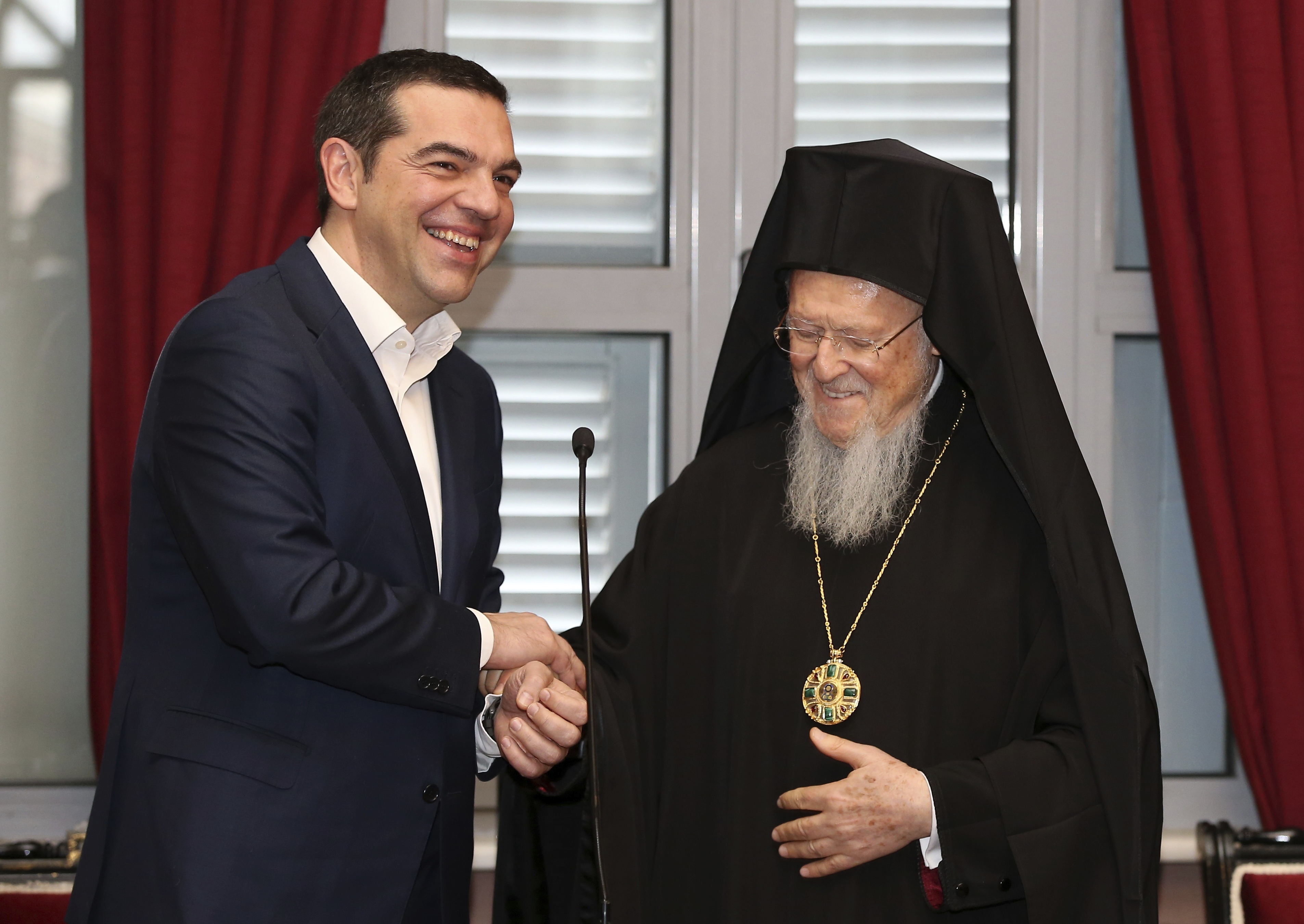 Greece's Prime Minister Alexis Tsipras, left, and Ecumenical Patriarch Bartholomew I laugh during their visit at the Theological School of Halki, in Heybeli Island, near Istanbul, Wednesday, Feb. 6, 2019. The president of Turkey and the prime minister of Greece agreed Tuesday on the need to keep 