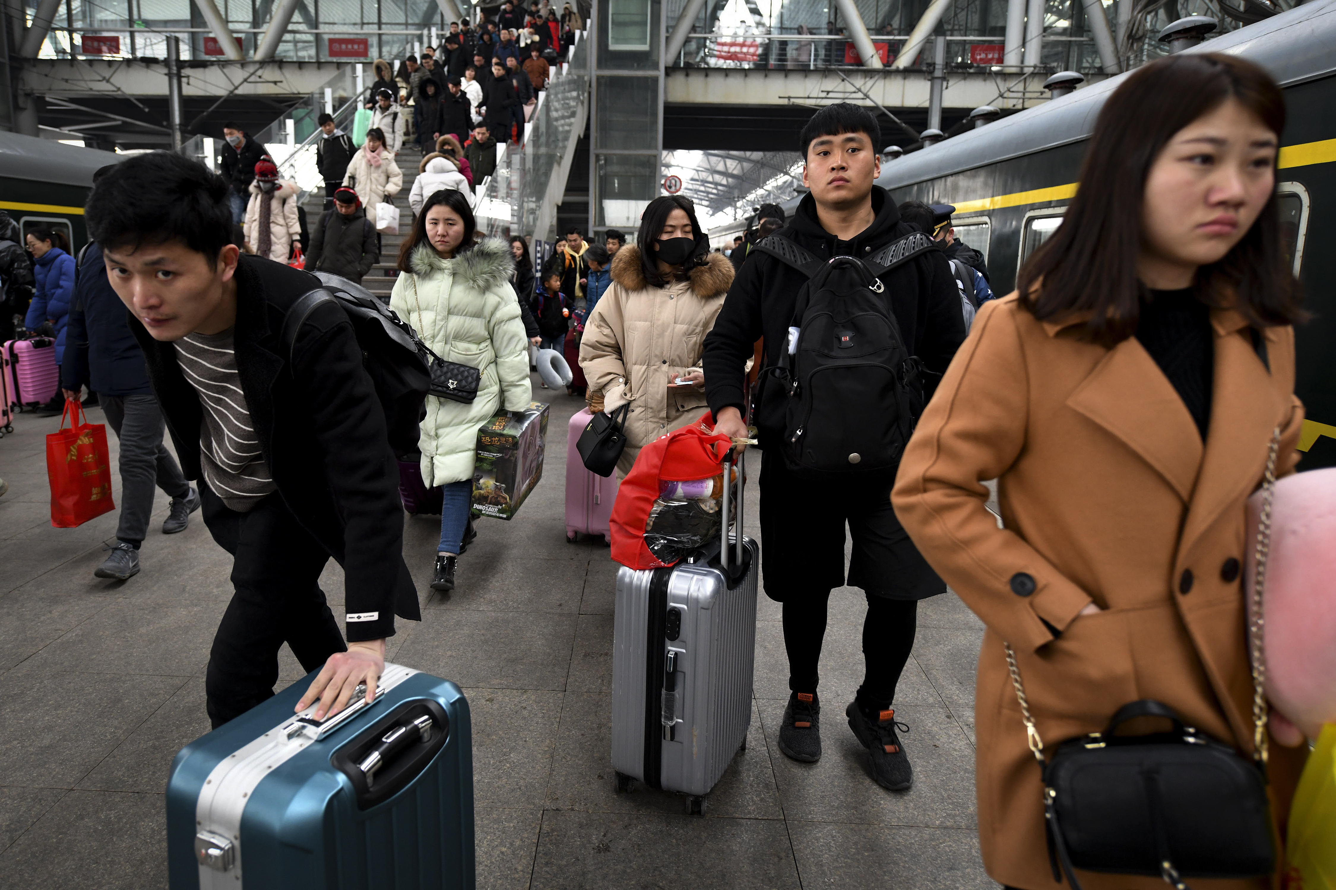 Chinese travelers with their luggage rush to catch their trains at a railway station in Fuyang in central China's Anhui province, Sunday, Feb. 10, 2019. Millions of Chinese are start returning to work after spending a weeklong Lunar New Year holiday with families in their hometown. (Chinatopix via AP)