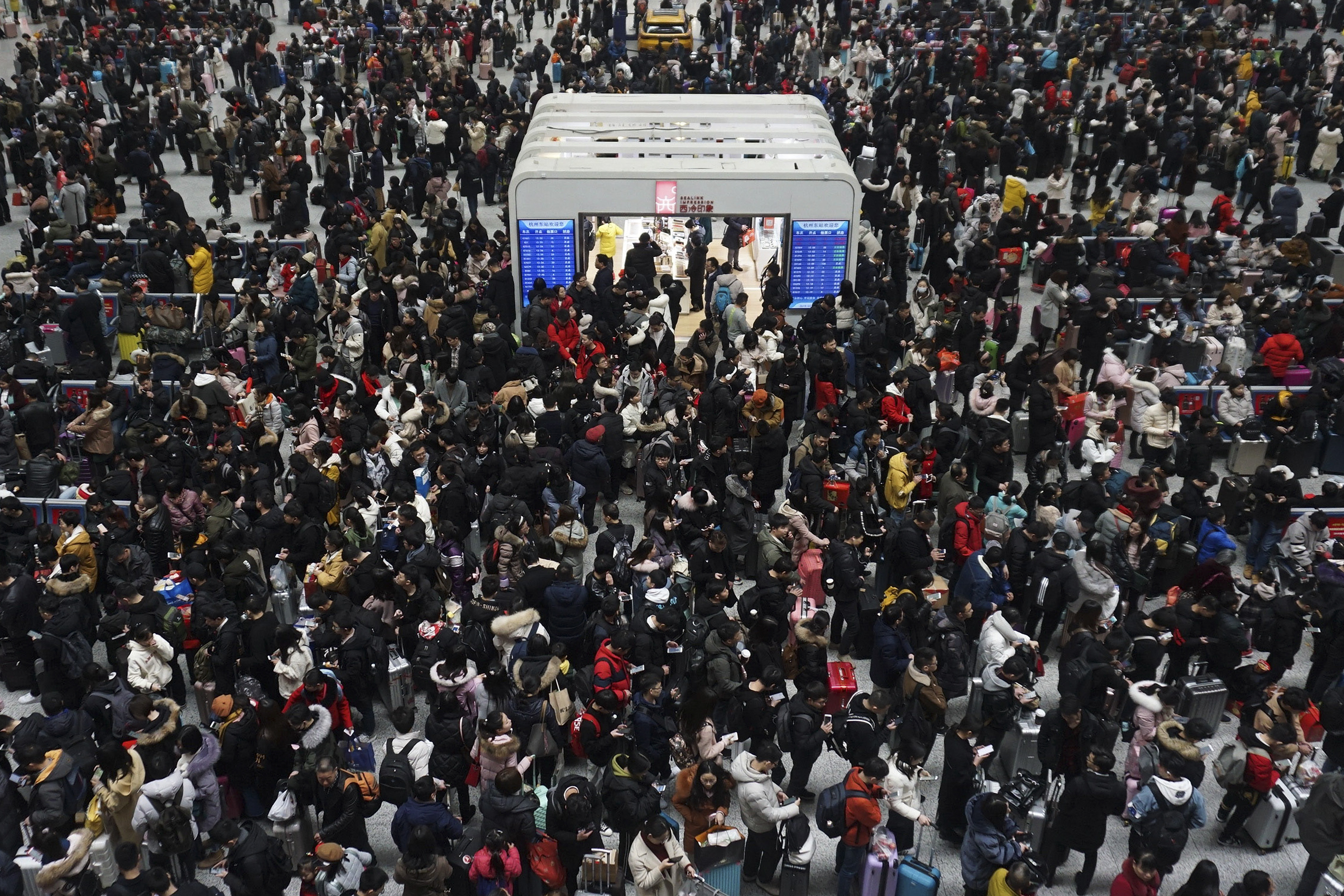 Chinese travelers wait for their trains at a railway station in Hangzhou in east China's Zhejiang province, Sunday, Feb. 10, 2019. Millions of Chinese are start returning to work after spending a weeklong Lunar New Year holiday with families in their hometown. (Chinatopix via AP)