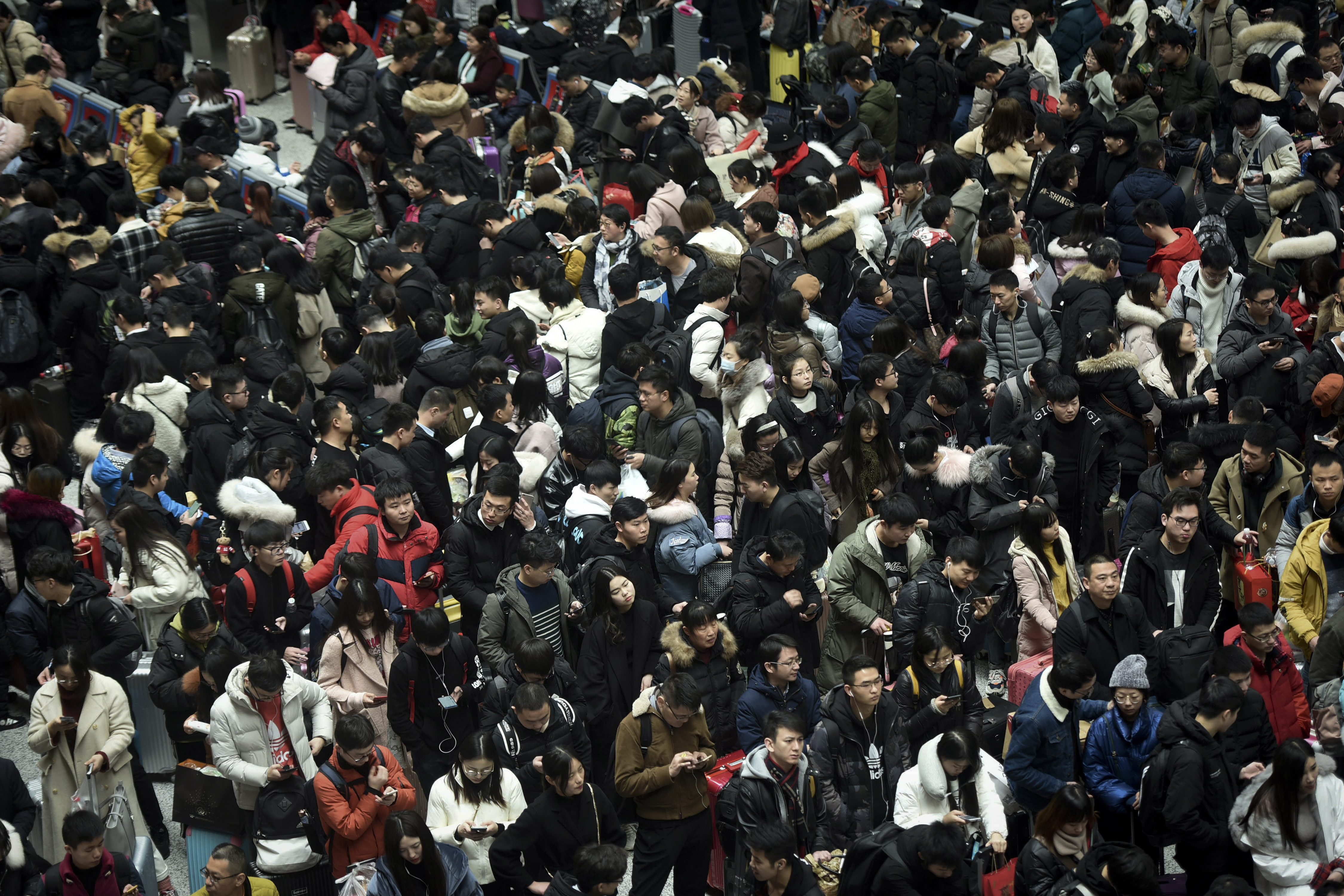 Chinese travelers crowd at a railway station as they wait for their trains in Hangzhou in east China's Zhejiang province, Sunday, Feb. 10, 2019. Millions of Chinese are start returning to work after spending a weeklong Lunar New Year holiday with families in their hometown. (Chinatopix via AP)