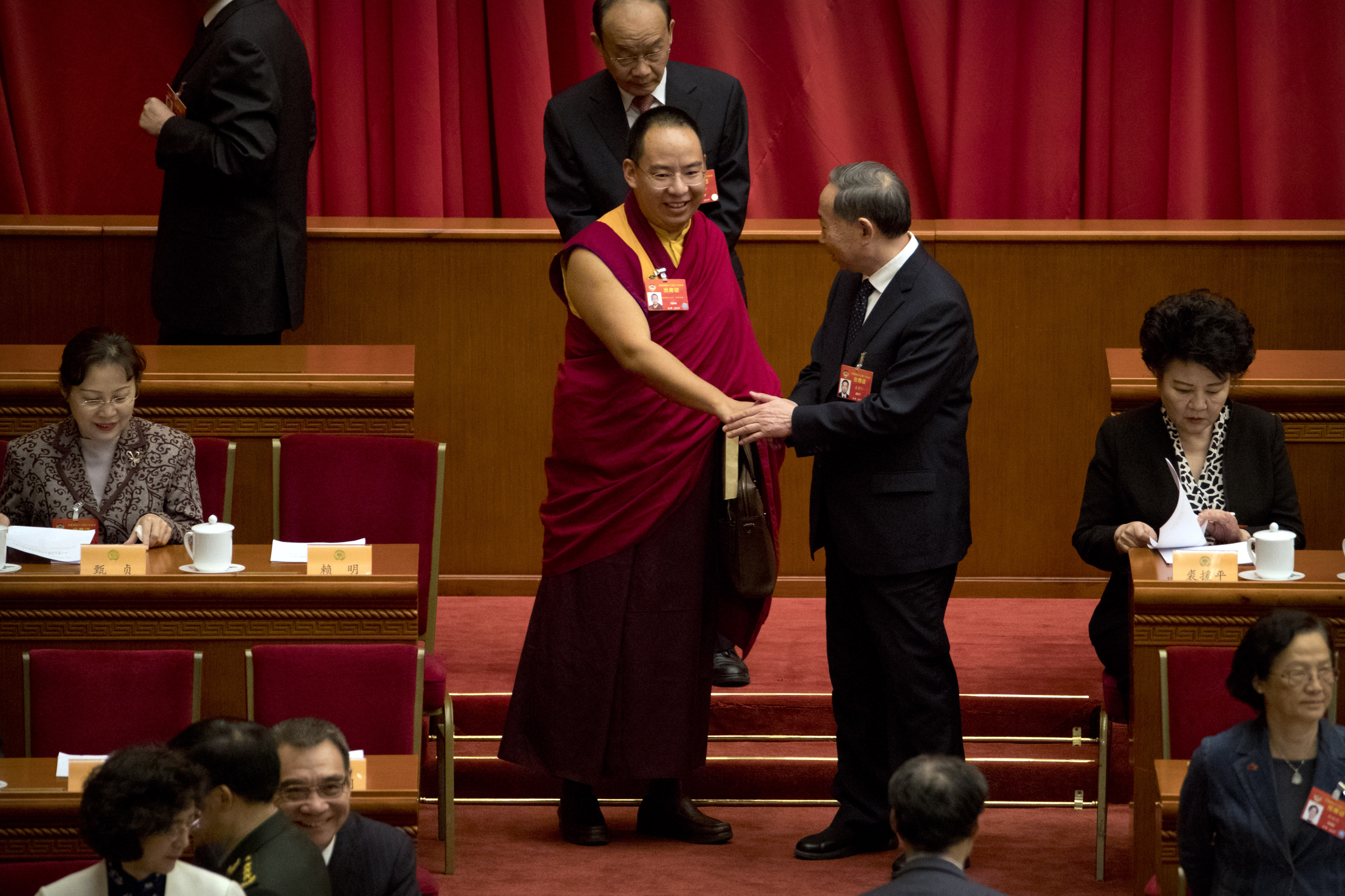 The 11th Panchen Lama Bainqen Erdini Qoigyijabu, a member of the National Committee of the Chinese People's Political Consultative Conference (CPPCC), is greeted as he arrives for the closing session of the CPPCC at the Great Hall of the People in Beijing, Wednesday, March 13, 2019. (AP Photo/Mark Schiefelbein)