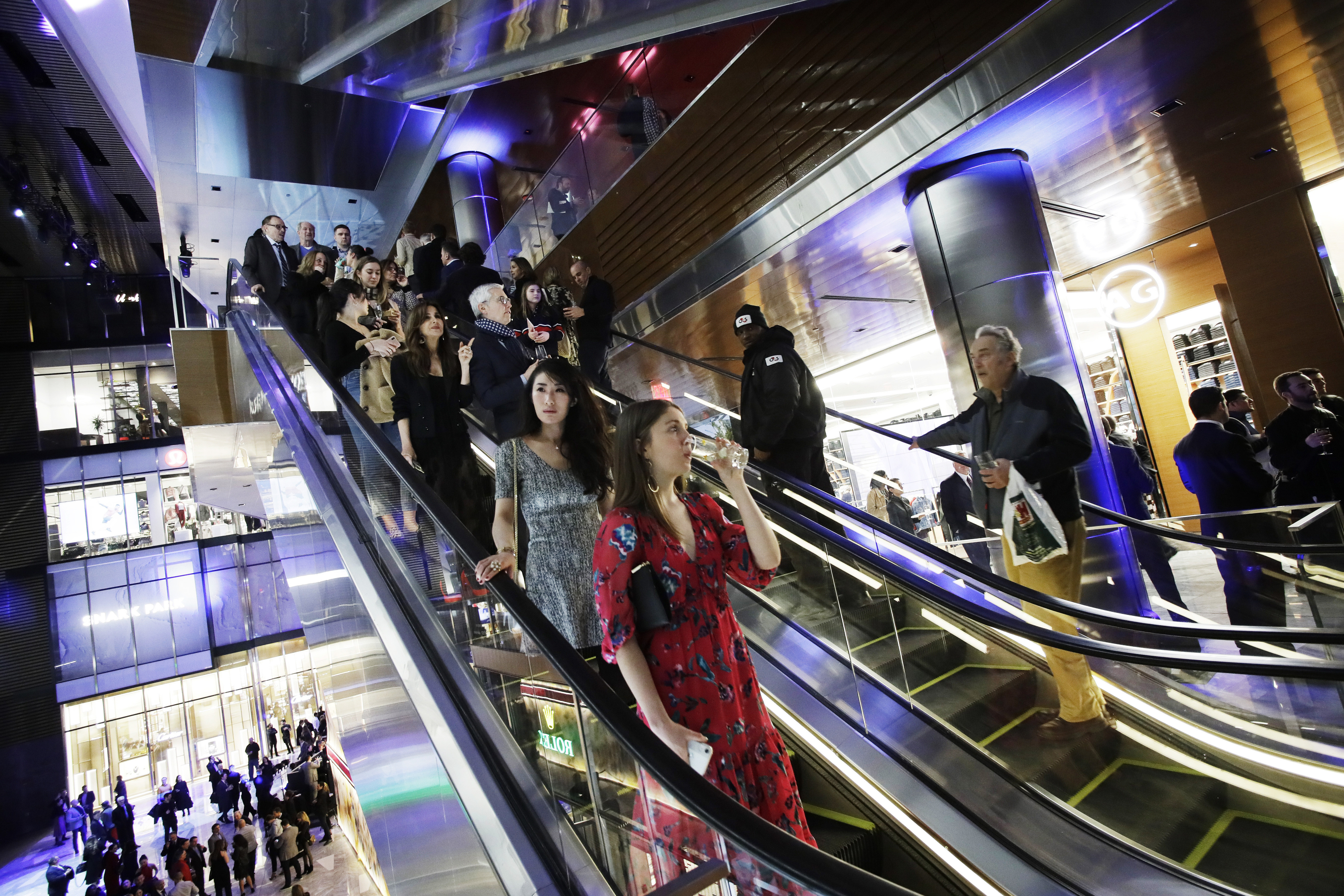 People attend the opening night of The Shops & Restaurants at Hudson Yards, Thursday, March 14, 2019, in New York. Hudson Yards, a $25 billion urban complex on Manhattan's west side, is the city's most ambitious development since the rebuilding of the World Trade Center. When fully complete, the 28-acre site will include 16 towers of homes and offices, a hotel, a school, the highest outdoor observation deck in the Western Hemisphere, a performing arts center and the shopping mall. (AP Photo/Mark Lennihan)