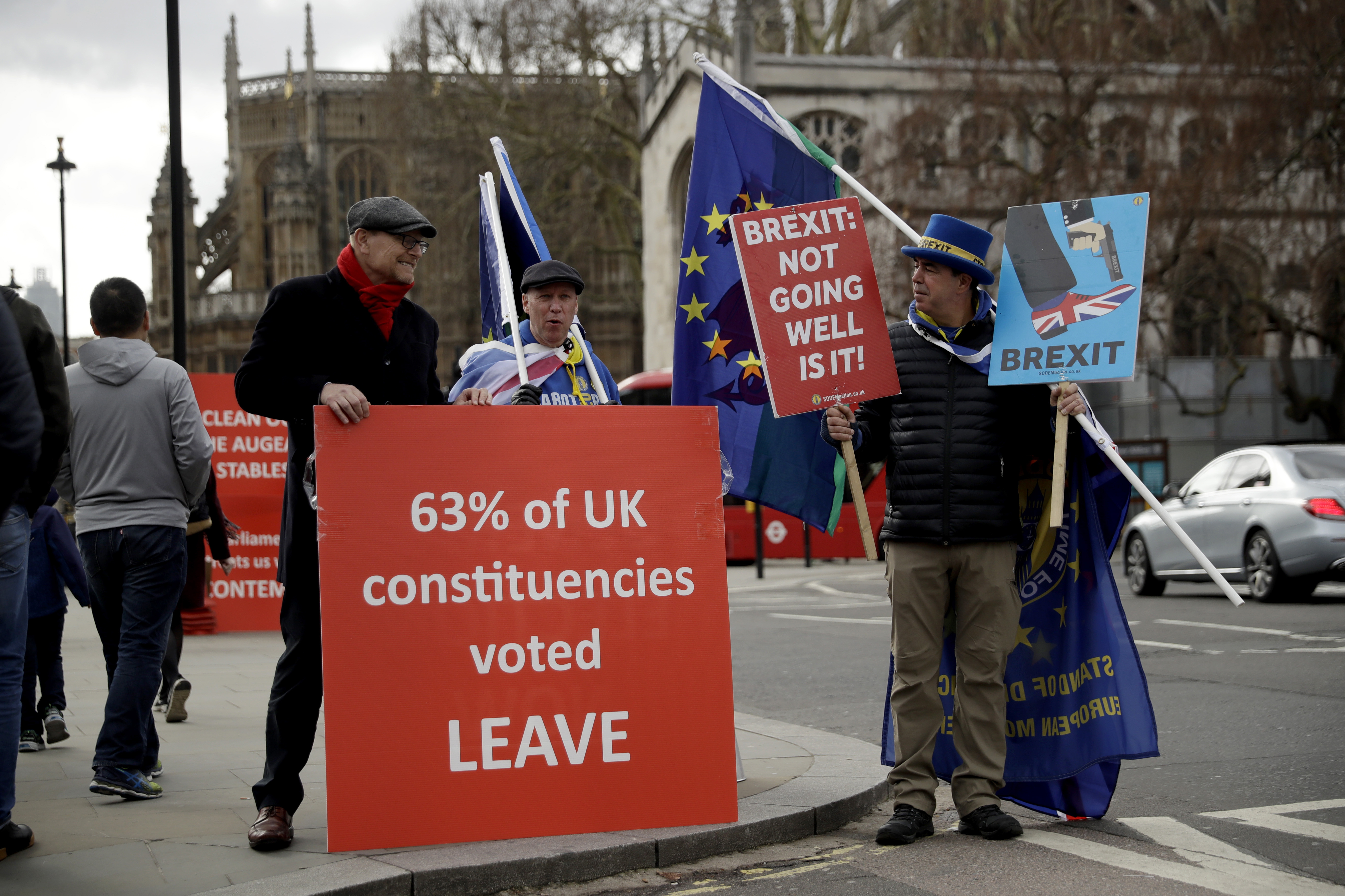 A pro-Brexit supporter, at left, protests next to anti-Brexit supporters protesting outside the Houses of Parliament in London, Monday, March 18, 2019. British Prime Minister Theresa May was making a last-minute push Monday to win support for her European Union divorce deal, warning opponents that failure to approve it would mean a long — and possibly indefinite — delay to Brexit. Parliament has rejected the agreement twice, but May aims to try a third time this week if she can persuade enough lawmakers to change their minds. (AP Photo/Matt Dunham)