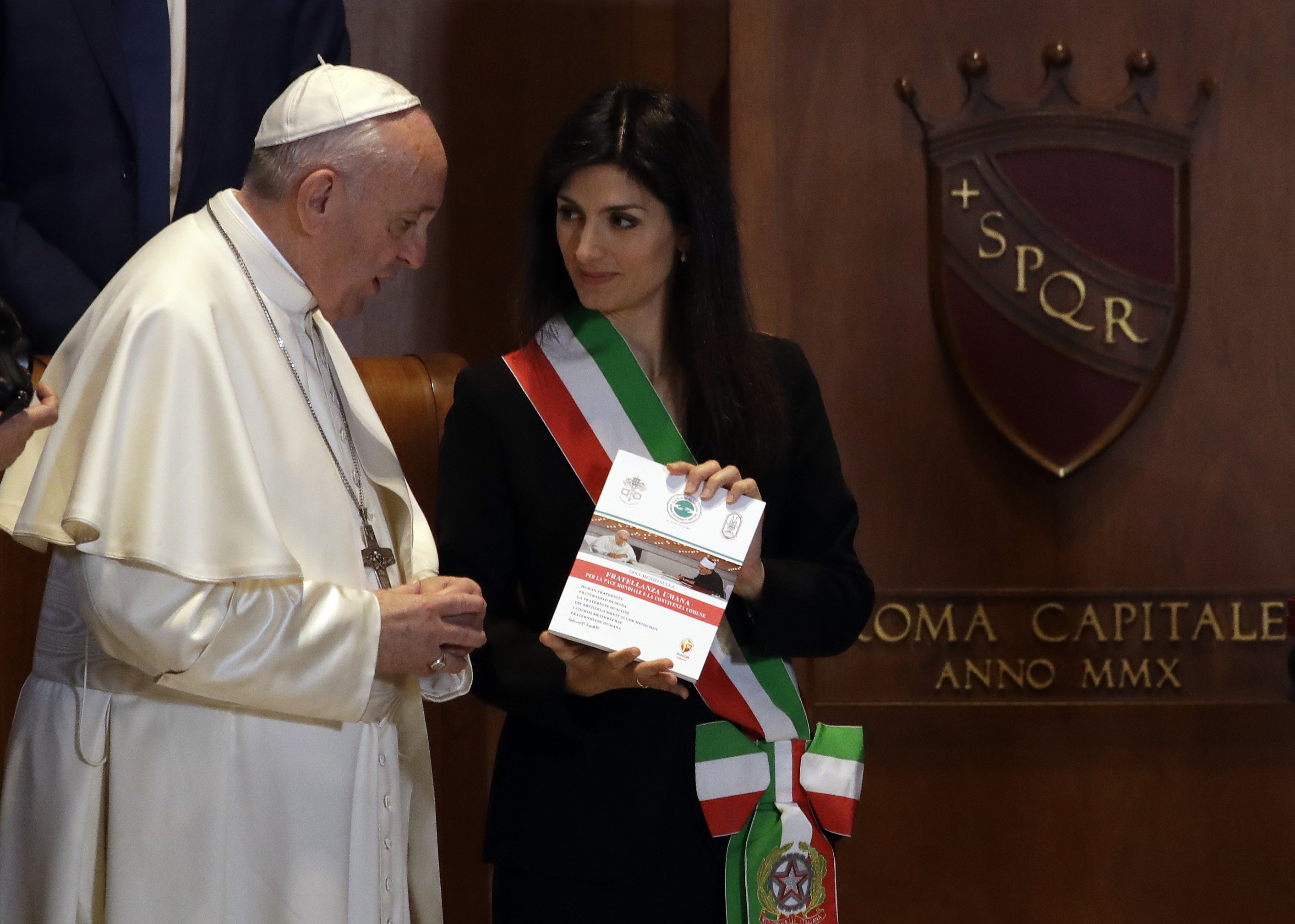 Pope Francis, exchanges gifts with Rome's Mayor Virginia Raggi, right, in the Julius Caesar Hall during his visit to the Campidoglio, Capitol Hill, in Rome, Tuesday, March 26, 2019. (AP Photo/Alessandra Tarantino)