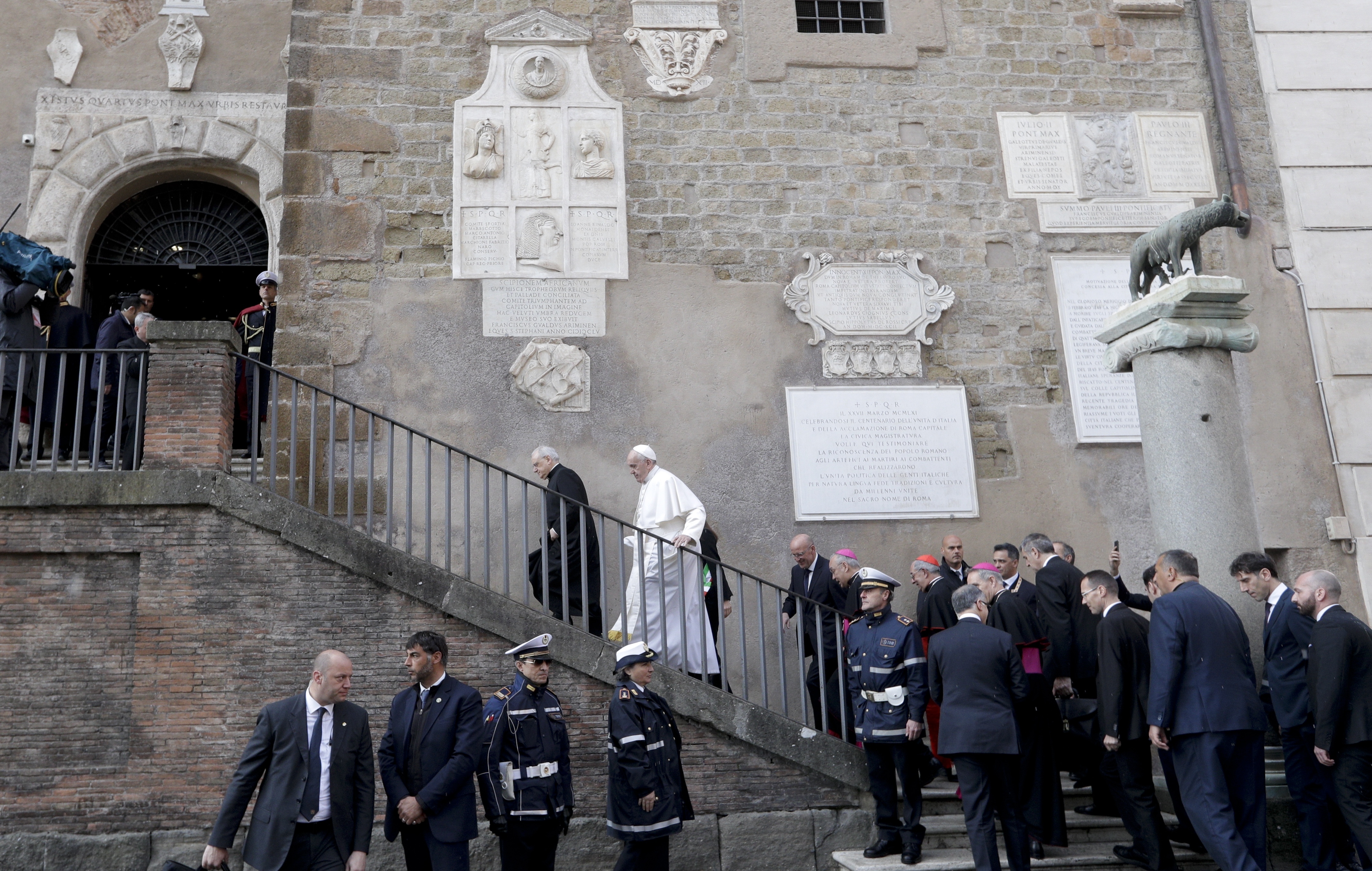 Pope Francis climbs the stairs leading to Rome Mayor's office as he arrives for his visit to the Rome's city hall, Tuesday, March 26, 2019. (AP Photo/Andrew Medichini)