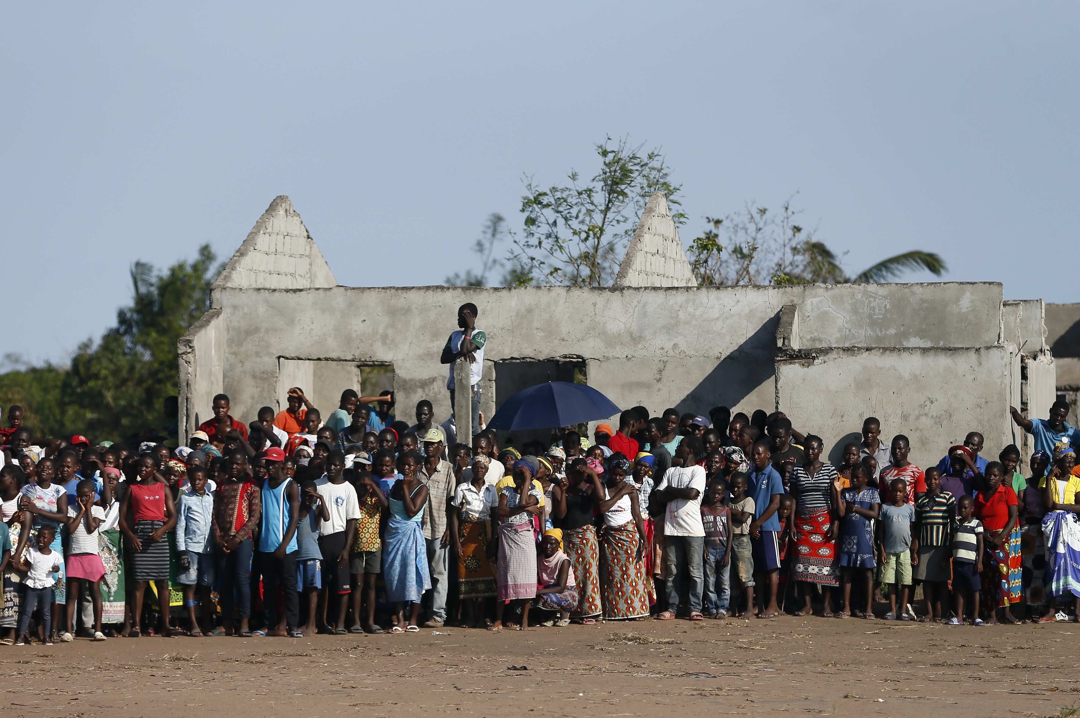 Locals from Gwaragwara stand the aid destribution point following the devastating Tropical Cyclone Idai in Beira, Mozambique, Tuesday, March 26, 2019. A second week has begun with efforts to find and help some tens of thousands of people in devastated parts of southern Africa, with some hundreds dead and an unknown number of people still missing. (AP Photo/Phill Magakoe)