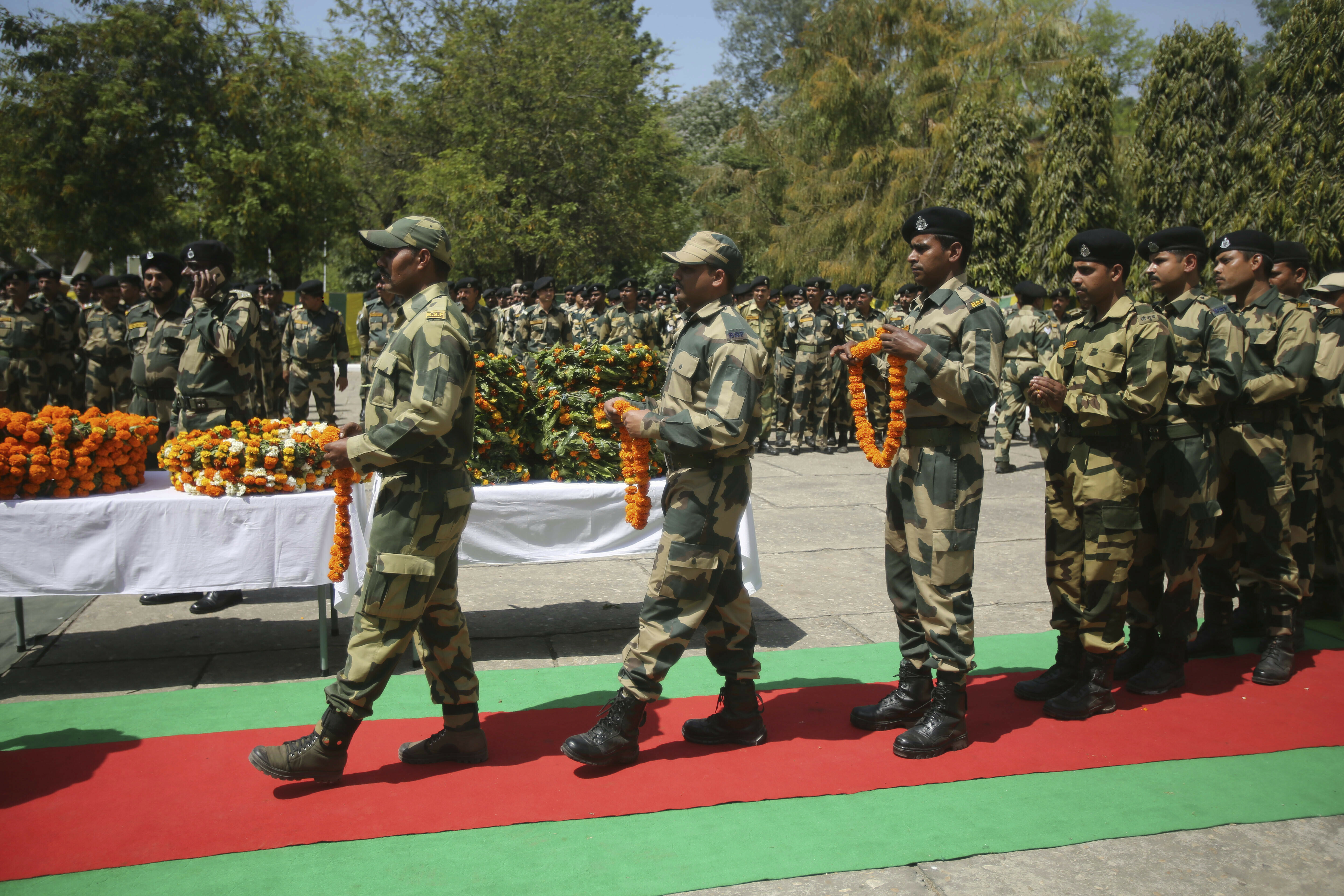 Indian Border Security Force (BSF) soldiers pay tribute to to their killed colleague T. Alex Lalminlun during a wreath-laying ceremony at the BSF headquarters in Jammu, India, Tuesday, April.2, 2019.  Pakistan and India traded fire in the disputed Himalayan region of Kashmir, leaving seven people dead — three Pakistani soldiers, a Pakistani villager, an Indian woman and a girl and a member of the Indian paramilitary troops, officials said Tuesday. (AP Photo/Channi Anand)