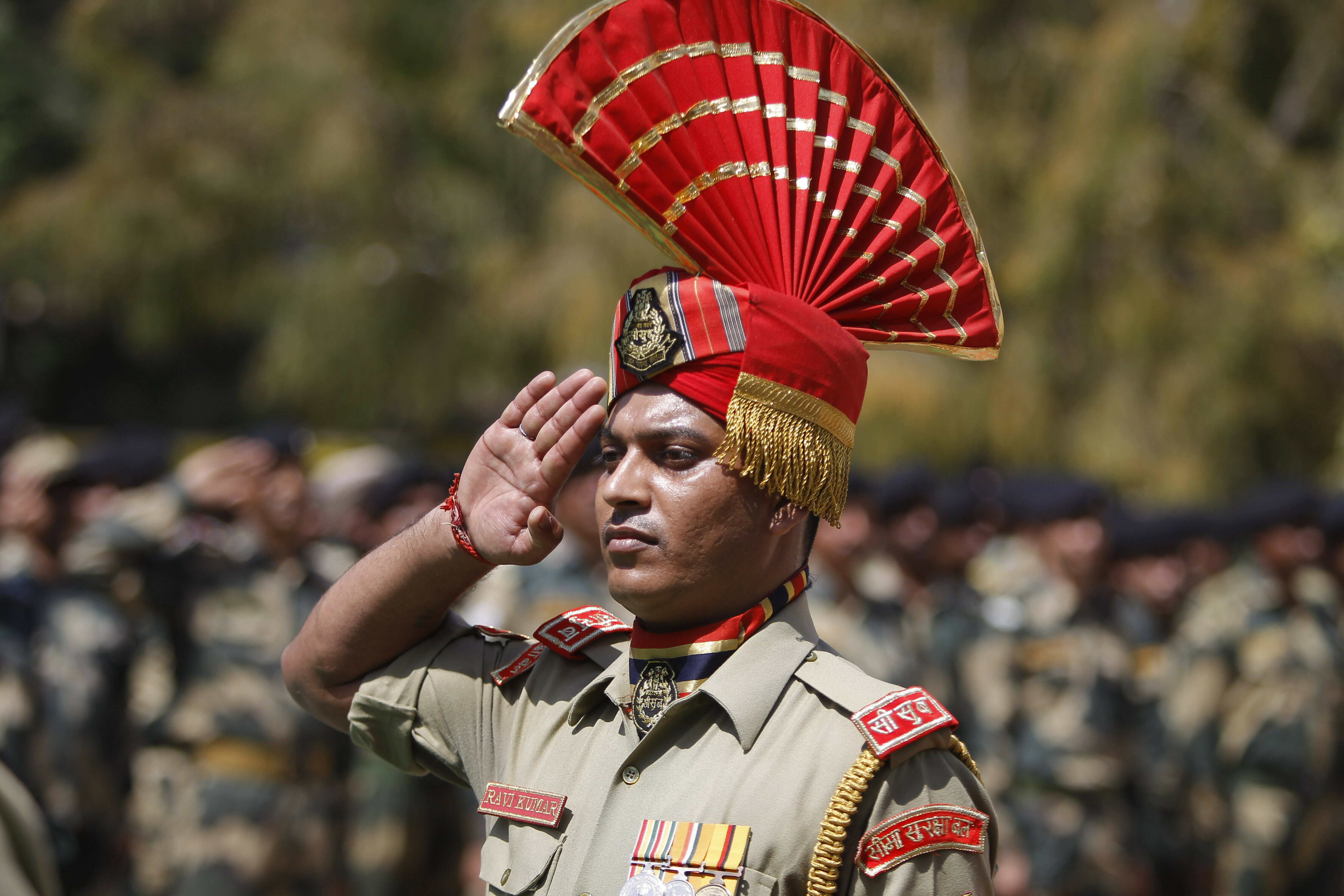 An Indian Border Security Force (BSF) soldier pays tribute to his colleague T. Alex Lalminlun during a wreath-laying ceremony at the BSF headquarters in Jammu, India, Tuesday, April.2, 2019.  Pakistan and India traded fire in the disputed Himalayan region of Kashmir, leaving seven people dead — three Pakistani soldiers, a Pakistani villager, an Indian woman and a girl and a member of the Indian paramilitary troops, officials said Tuesday. (AP Photo/Channi Anand)