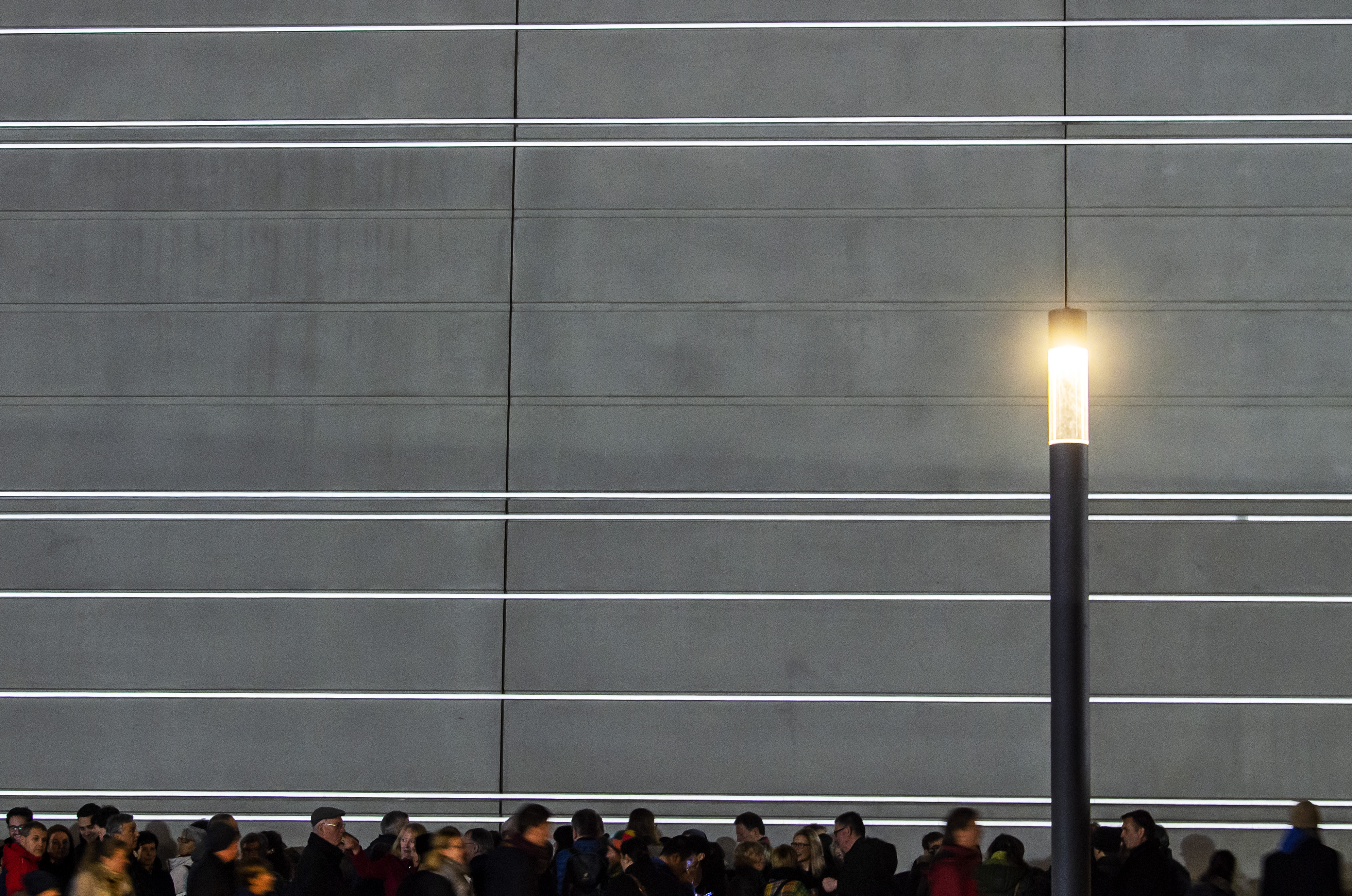 People stand in front of the new Bauhaus Museum building during a light installation performance at the official opening by the Klassik Stiftung Weimar in Weimar, Germany, Friday, April 5, 2019. The museum, designed by Berlin-based Heike Hanada, will focus on the early Bauhaus that was founded in Weimar in 1919 and stayed there until 1925. (AP Photo/Jens Meyer)