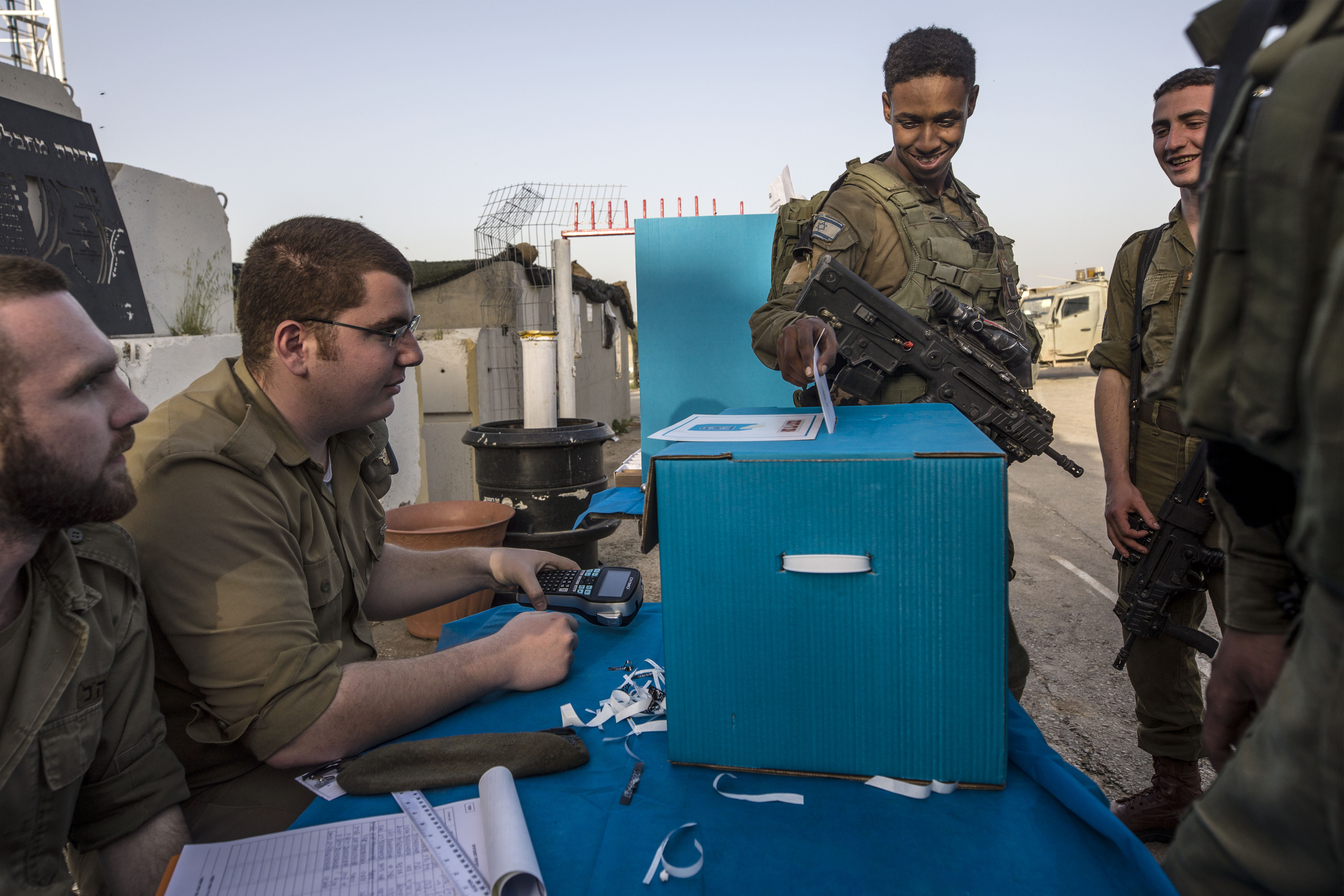Israeli soldiers cast their ballots oat a mobile voting booth, two days before polling stations open in the rest of Israel, at a military post on the northern Israel and Gaza border, Sunday, April 7, 2019. (AP Photo/Tsafrir Abayov)