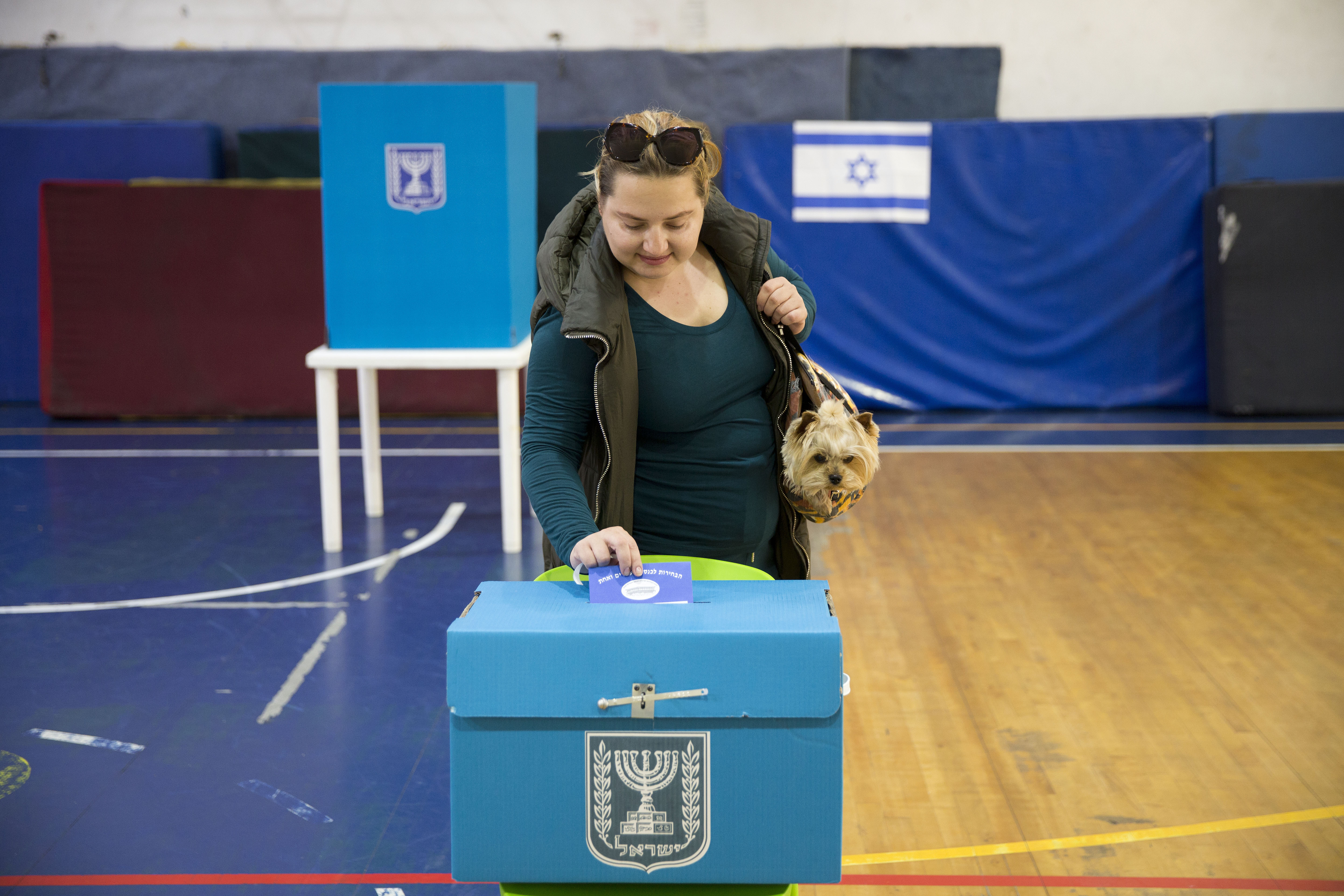 An Israeli woman casts her ballot for Israel's parliamentary election at a polling station in Ramat Gan, Israel, Tuesday, April 9, 2019. (AP Photo/Oded Balilty)