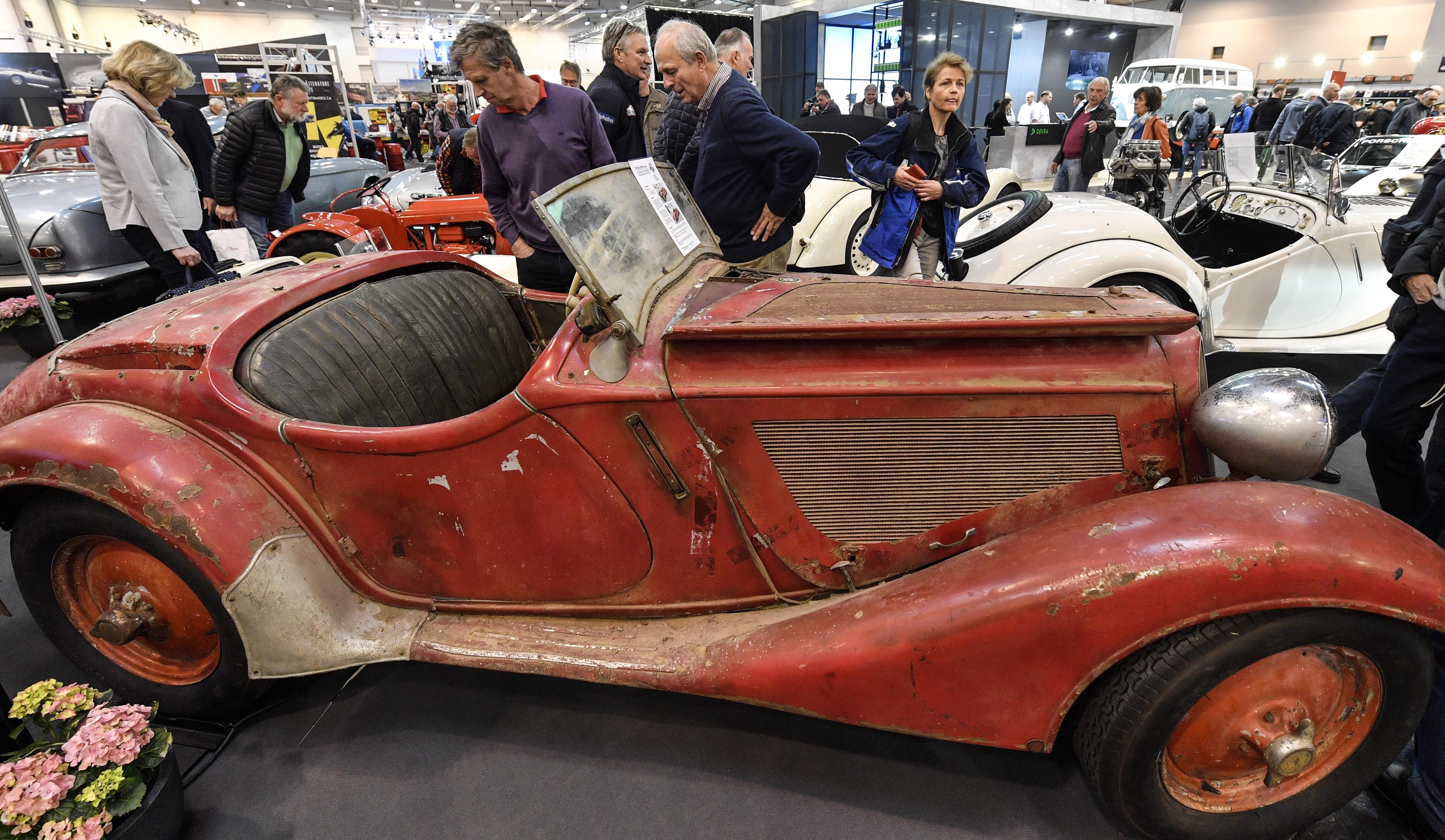 Visitors watch a BMW 328 Roadster from 1938 ready for restoration at the World Show for Vintage, Classic and Prestige Automobiles Techno-Classica in Essen, Germany, Friday, April 12, 2019. (AP Photo/Martin Meissner)