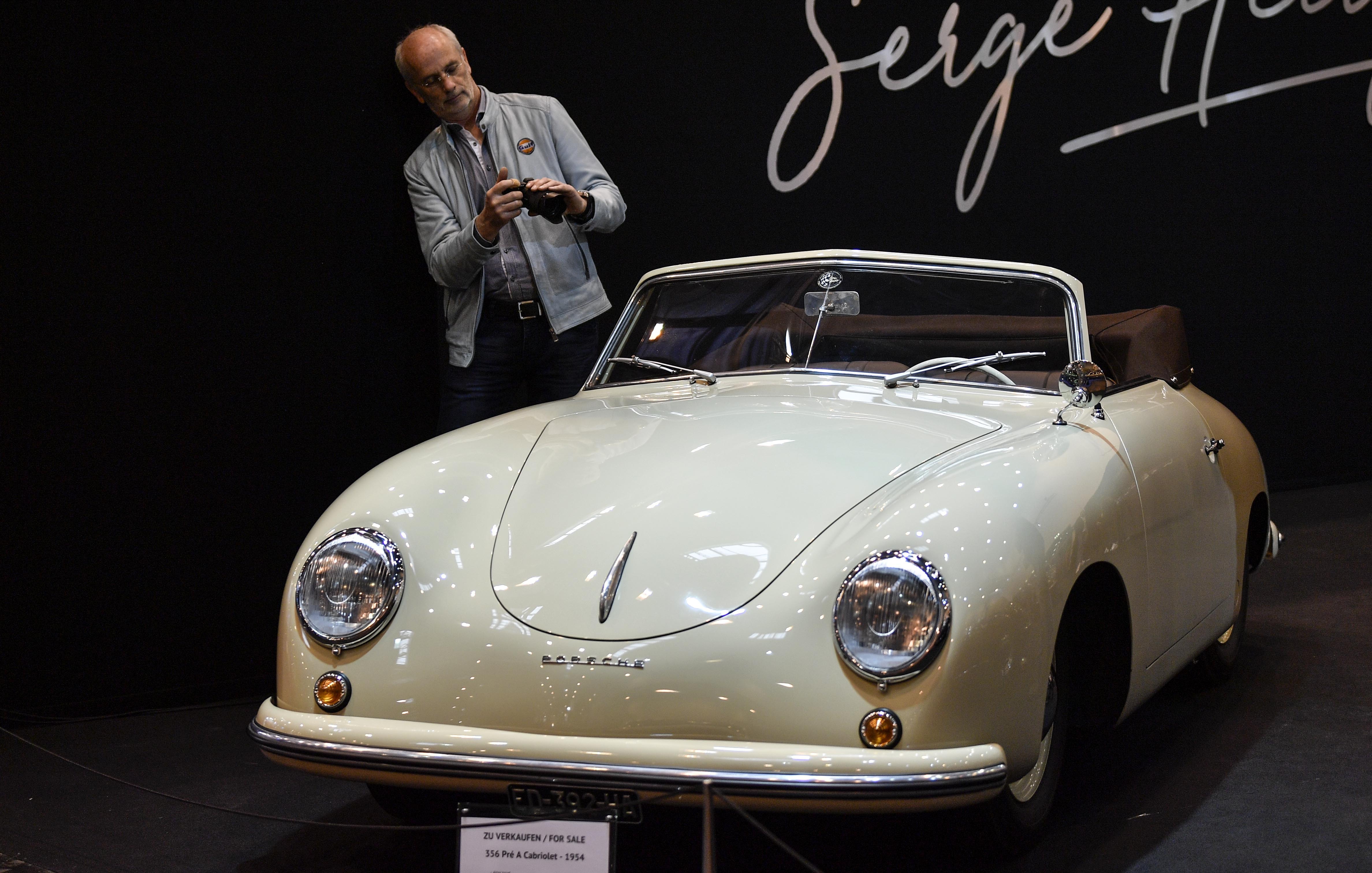 A man takes a picture of a Porsche 356 Cabriolet from 1954 on sale at the World Show for Vintage, Classic and Prestige Automobiles Techno-Classica in Essen, Germany, Friday, April 12, 2019. (AP Photo/Martin Meissner)