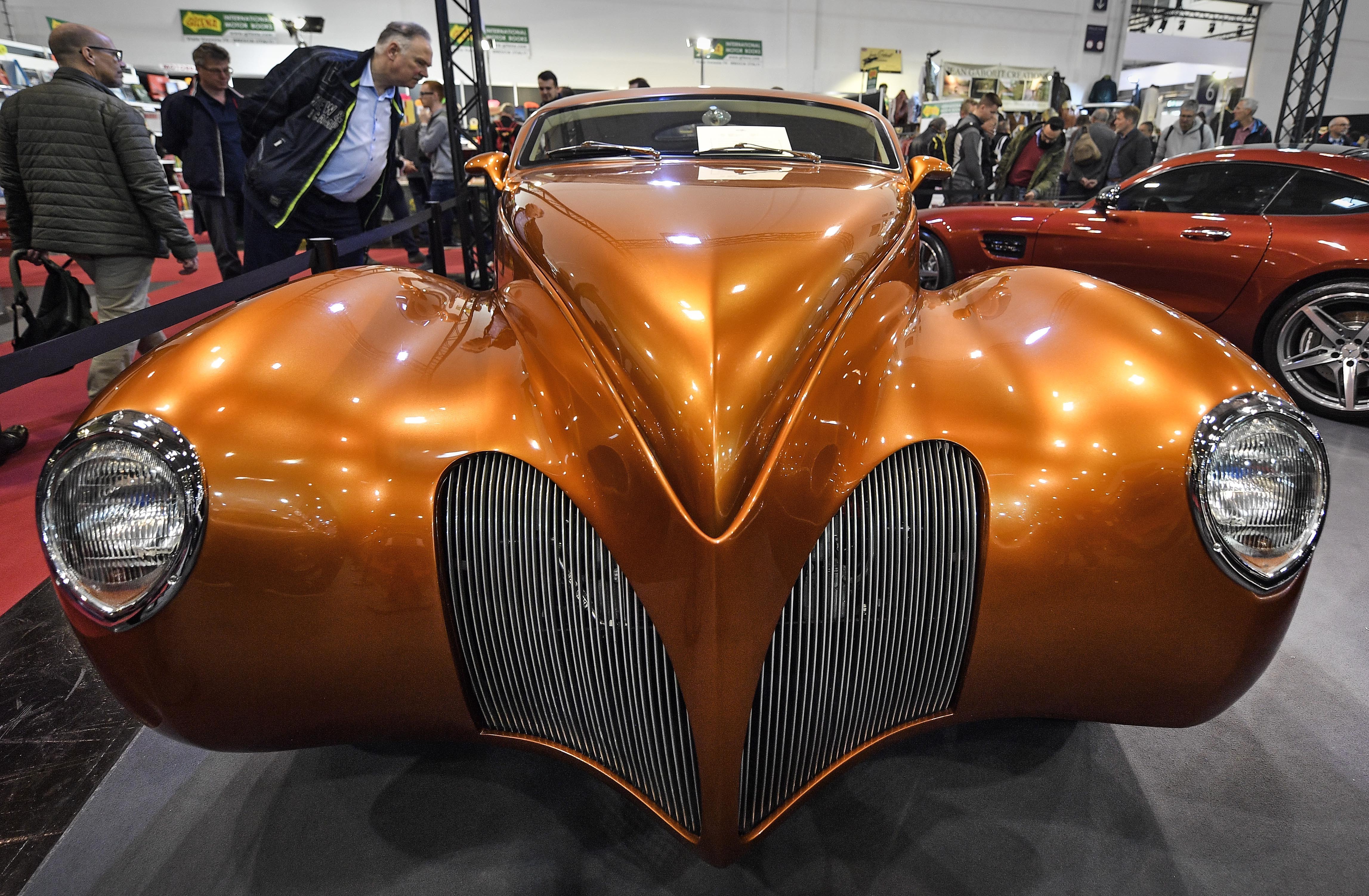Visitors watch a Lincoln Zephyr 'El Zorro' vintage car from 1939 at the World Show for Vintage, Classic and Prestige Automobiles Techno-Classica in Essen, Germany, Friday, April 12, 2019. (AP Photo/Martin Meissner)