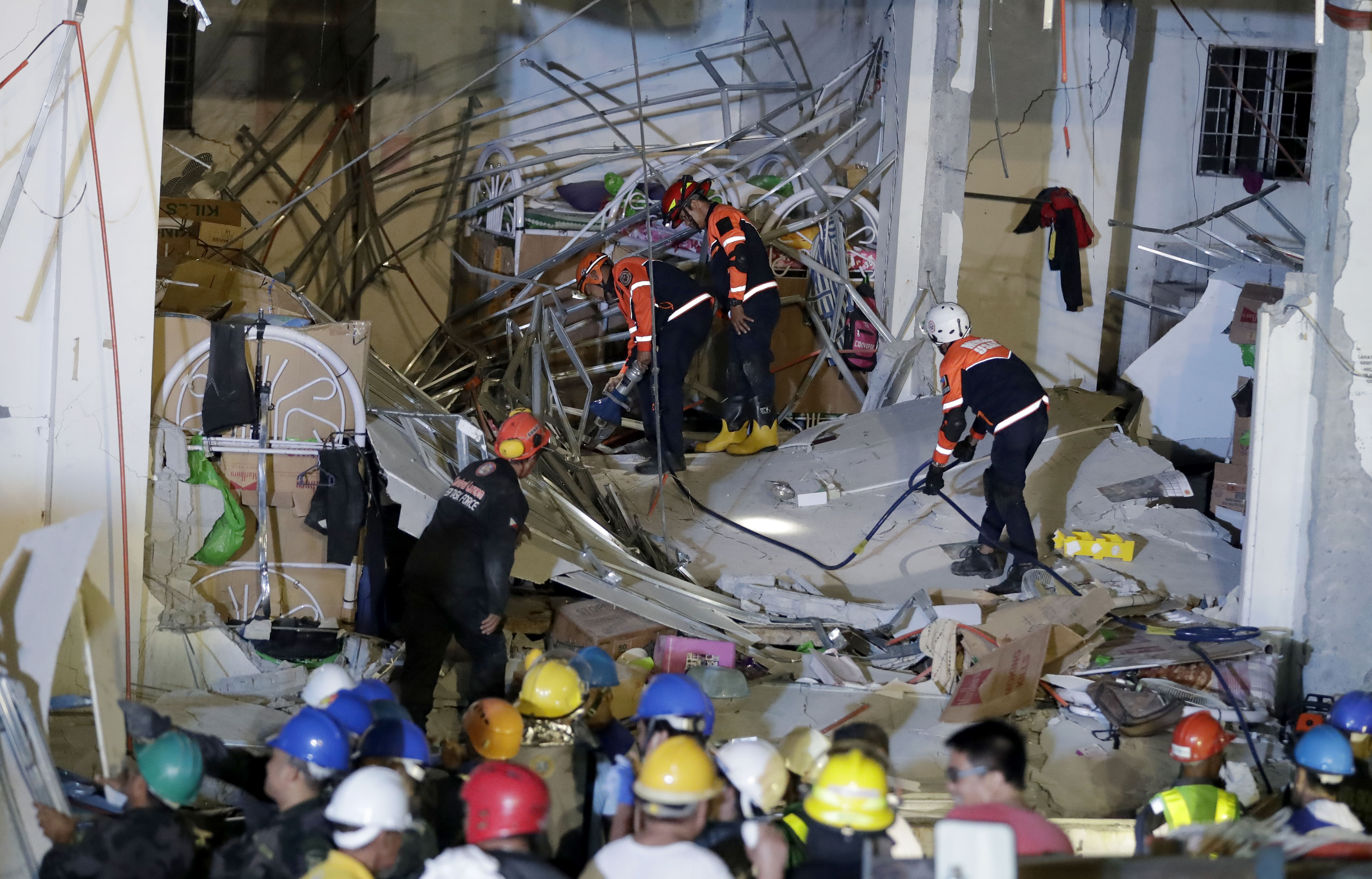 Rescuers continue to search for survivors following Monday's magnitude 6.1 earthquake that caused the collapse of a commercial building in Porac township, Pampanga province north of Manila, Philippines, Tuesday, April 23, 2019. A strong earthquake struck the northern Philippines Monday trapping some people in a collapsed building, damaging an airport terminal and knocking out power in at least one province, officials said. (AP Photo/Bullit Marquez)