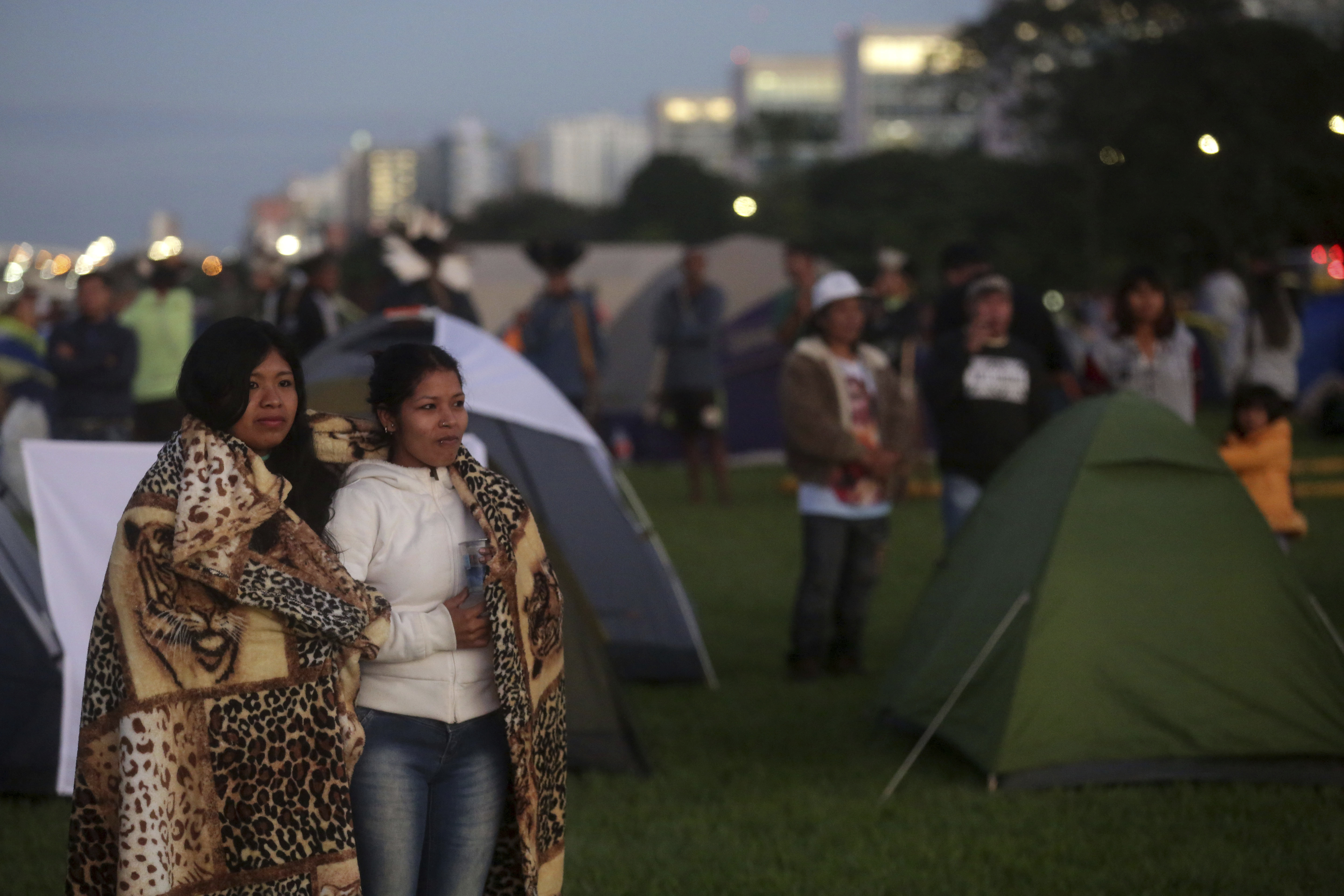Indigenous peoples rise at sunset during an annual three-day campout protest known as the Free Land Encampment, in Brasilia, Brazil, Wednesday, April 24, 2019. The event begins amid animosity between Brazil’s indigenous groups and the new government of far-right President Jair Bolsonaro. (AP Photo/Eraldo Peres)