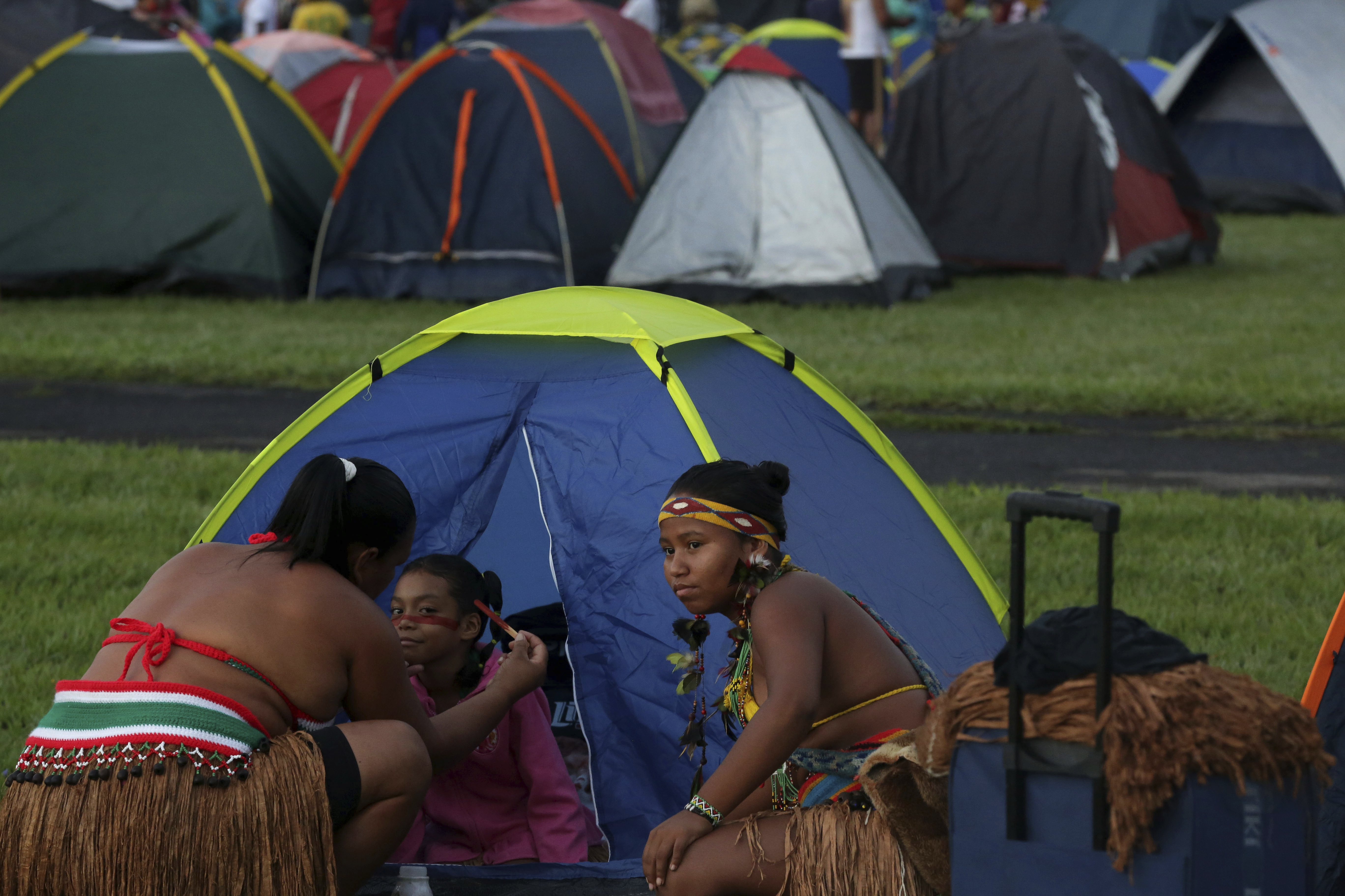 An indigenous mother applies body paint on her daughter during an annual three-day campout protest known as the Free Land Encampment, in Brasilia, Brazil, Wednesday, April 24, 2019. The event begins amid animosity between Brazil’s indigenous groups and the new government of far-right President Jair Bolsonaro. (AP Photo/Eraldo Peres)