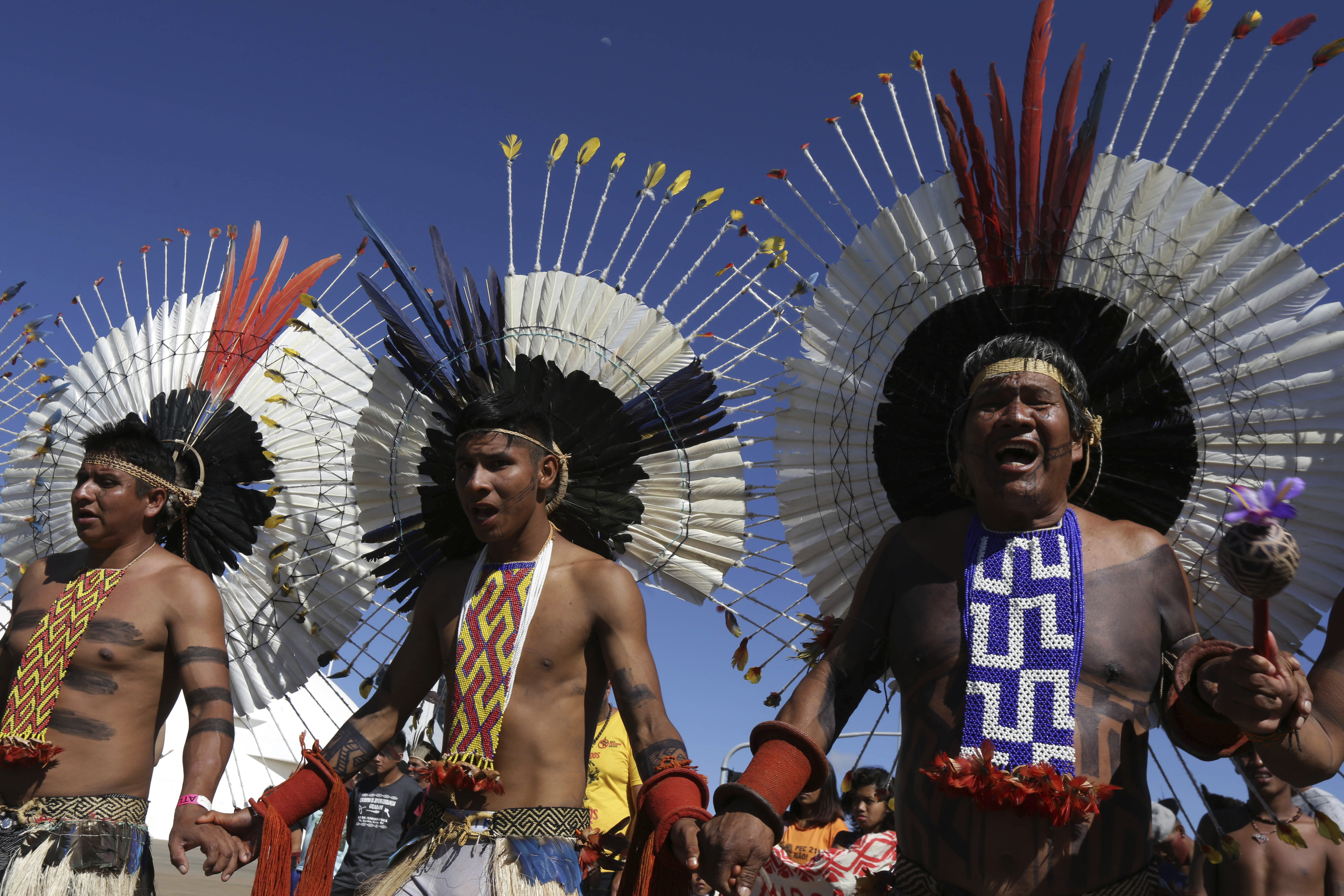Kamaiuras indigenous men sing ritual songs during the big march of the annual three-day campout protest known as The Free Land Encampment, to protest what they see as rollbacks of indigenous rights under President Jair Bolsonaro, in Brasilia, Brazil, Friday, April 26, 2019. Before becoming president, Bolsonaro promised that if he were elected, 