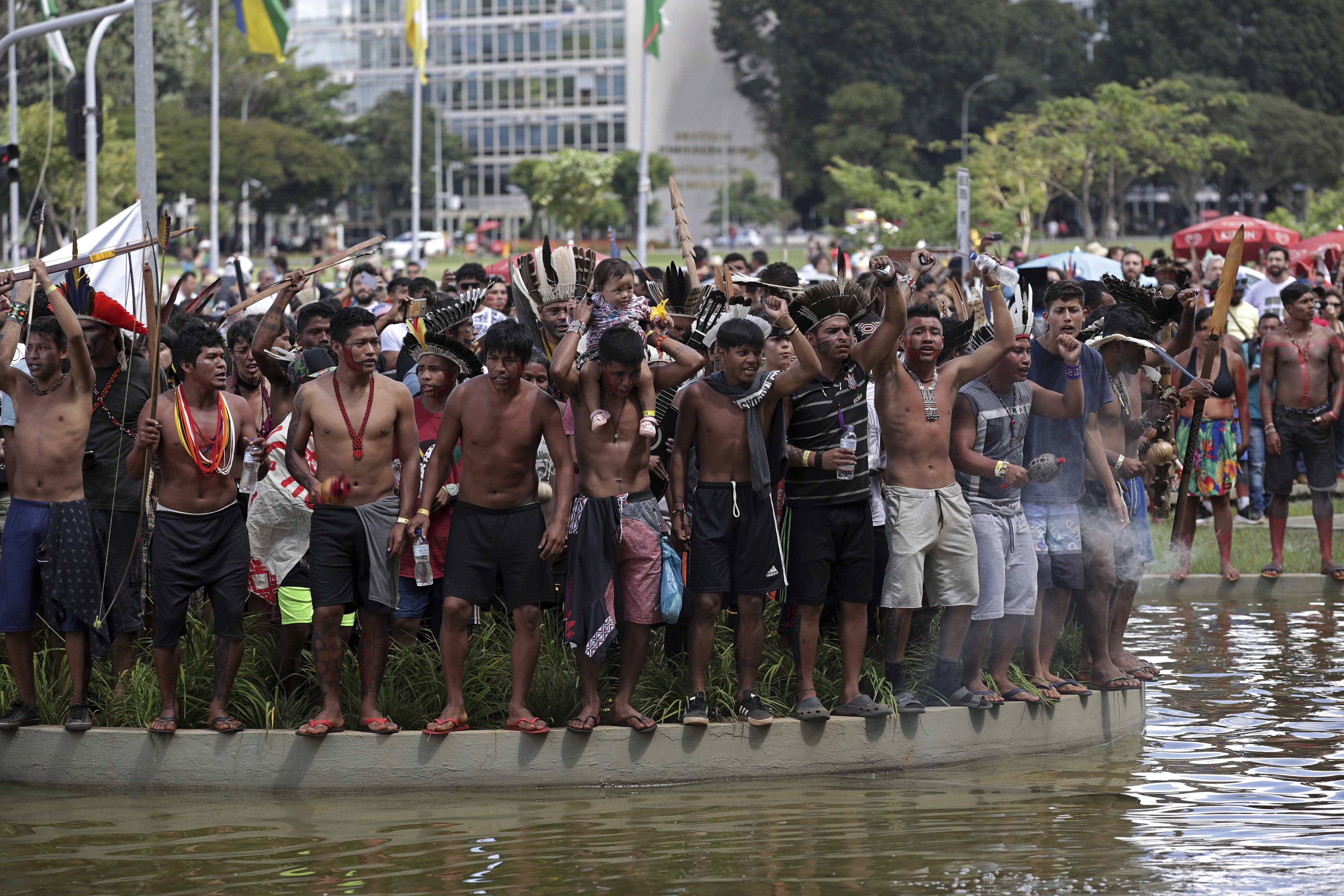 Indigenous men demonstrate in front of the headquarters of the Ministry of Justice, during the big march of the annual three-day campout known as The Free Land Encampment, to protest what they see as rollbacks of indigenous rights under President Jair Bolsonaro, in Brasilia, Brazil, Friday, April 26, 2019. Before becoming president, Bolsonaro promised that if he were elected, 