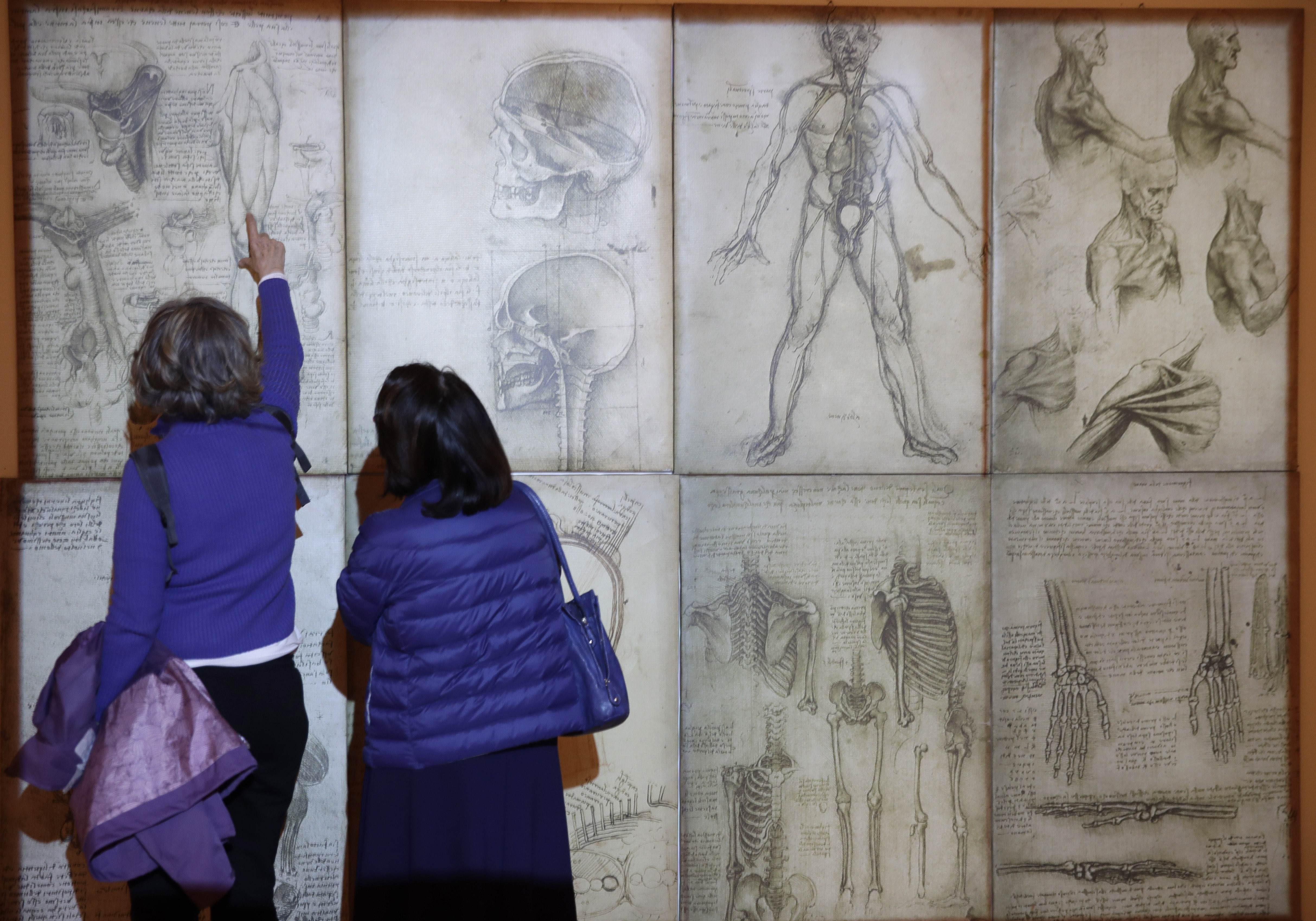 Visitors look at copies of his drawings by Italian Renaissance painter, scientist and inventor Leonardo Da Vinci during a permanent exhibition on Da Vinci, on the exact day commemorating the 500th anniversary of his death, in Rome, Thursday, May 2, 2019. Leonardo died in Amboise, France, on May 2, 1519.  (AP Photo/Alessandra Tarantino)