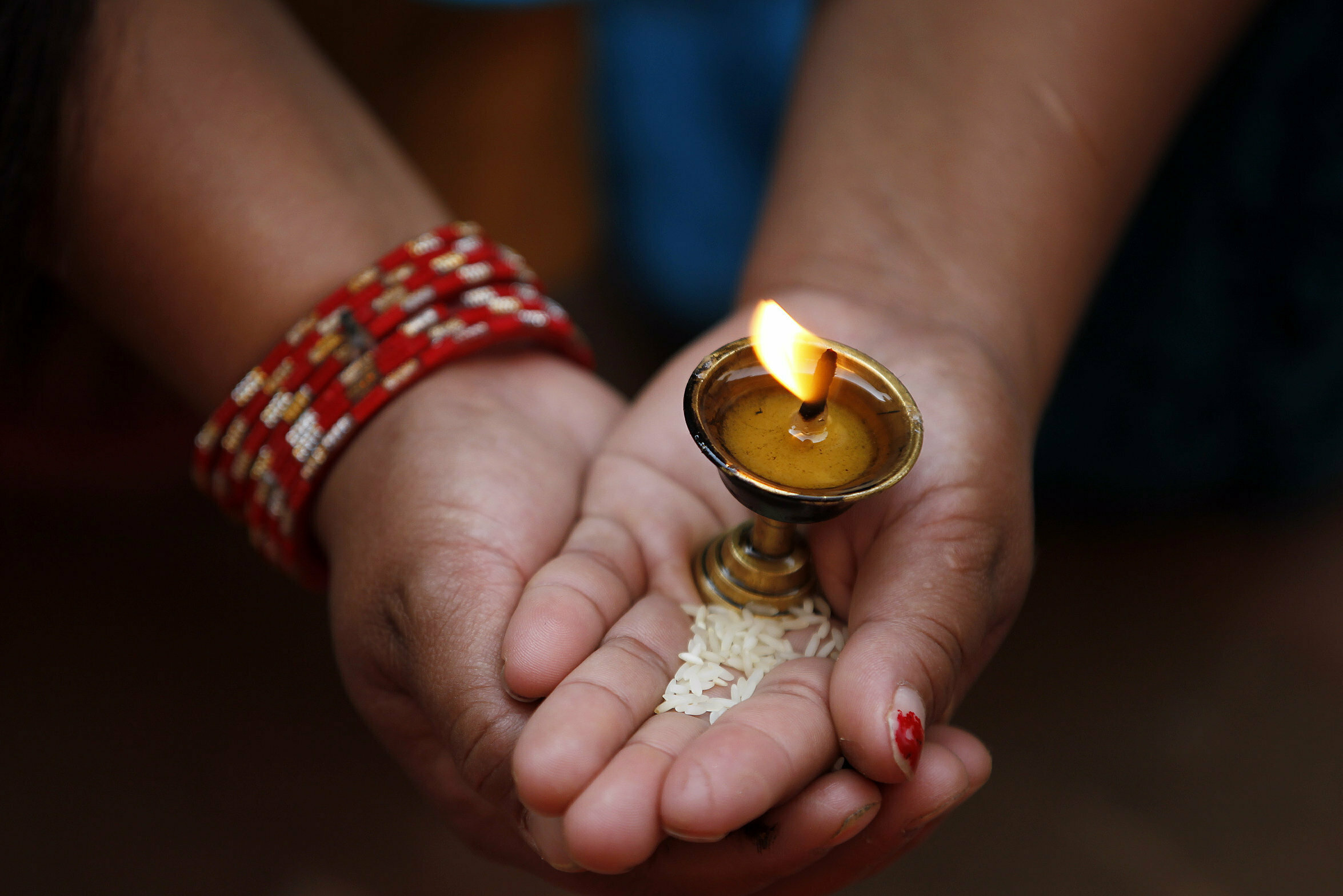 A Buddhist devotee holds a butter lamp during Buddha Jayanti, or Buddha Purnima, festival in Kathmandu, Nepal, Saturday, May 18, 2019. The festival marks the triple events of Gautam Buddha's life: his birth, his enlightenment and his attaining a state of Nirvana that frees believers from the circle of death and rebirth. (AP Photo/Niranjan Shrestha)