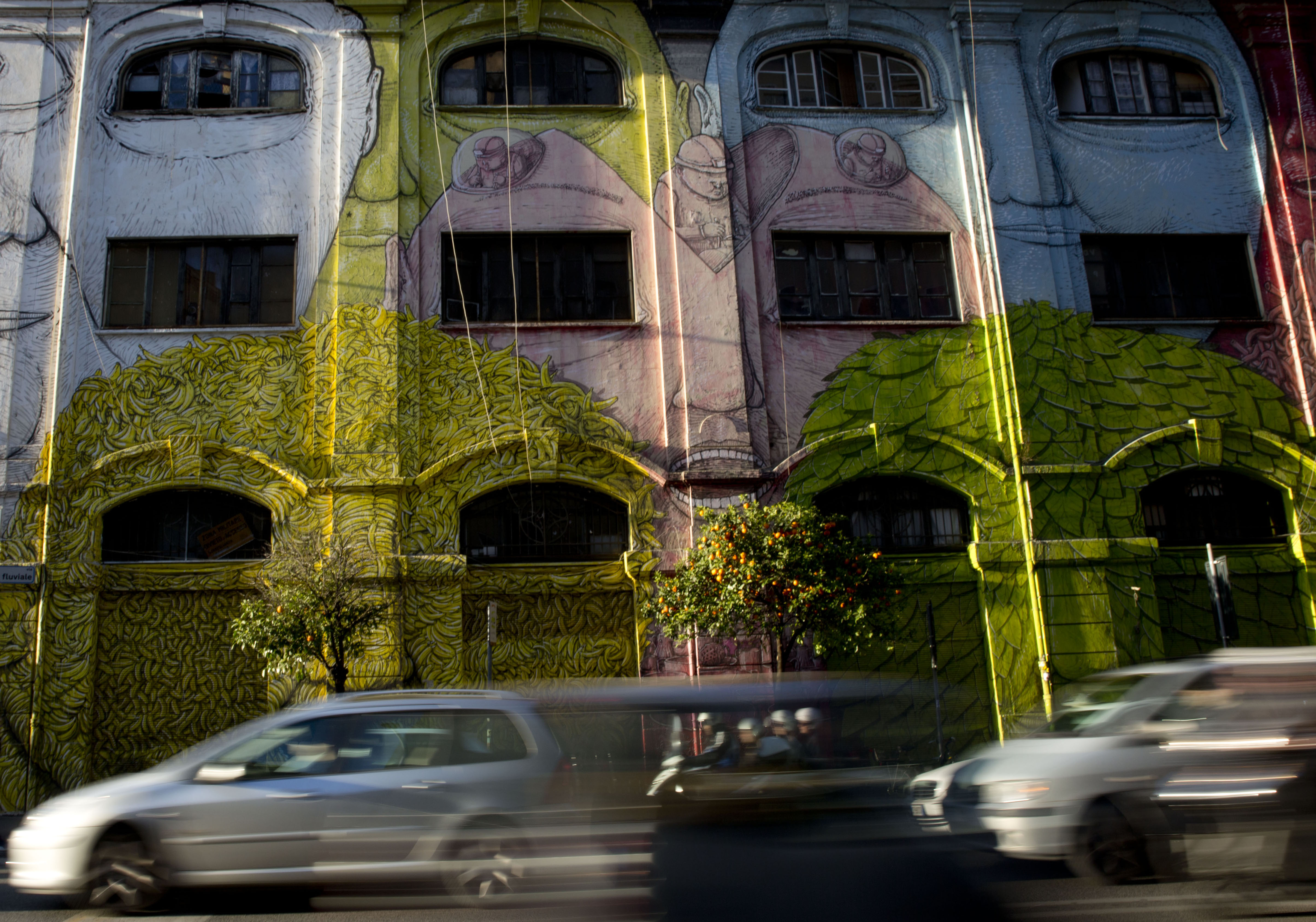 Cars run past a mural painted by Italian artist Blu in Rome, Wednesday, April 1, 2015. (AP Photo/Alessandra Tarantino)