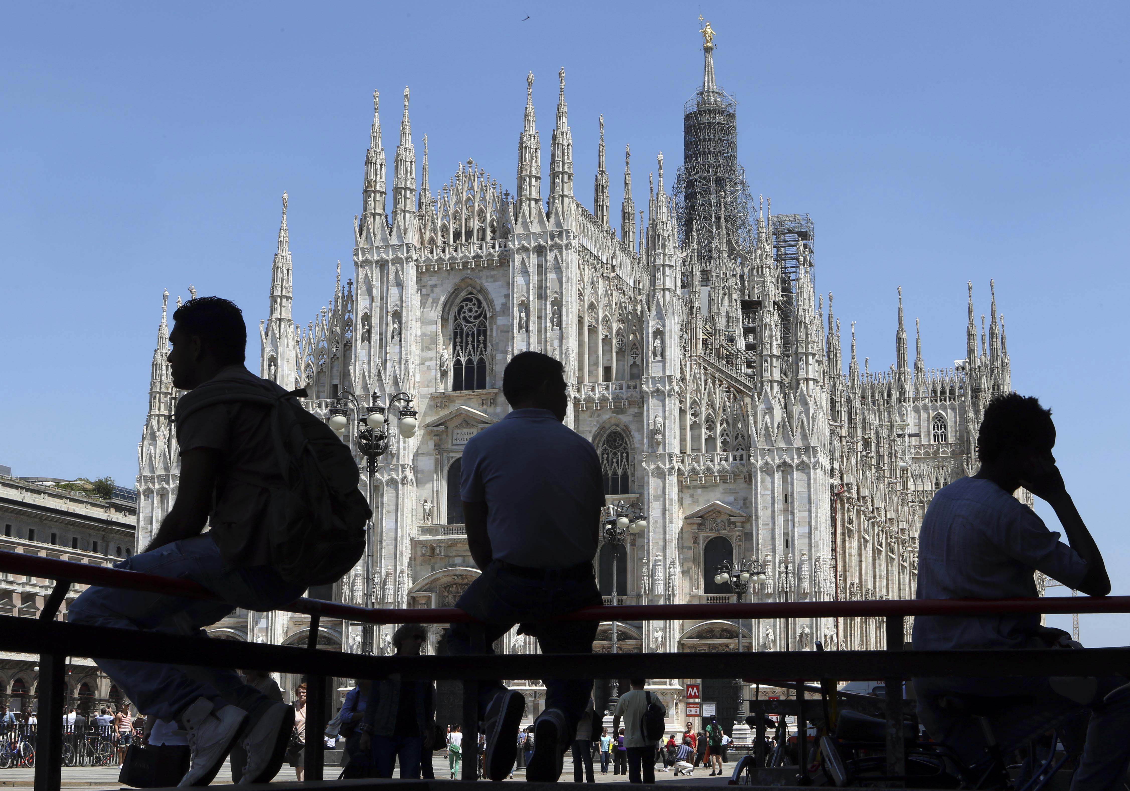 People are silhouetted as they sit in front of the Duomo gothic cathedral in Milan, Italy, Tuesday, June 11, 2013. (AP Photo/Luca Bruno)