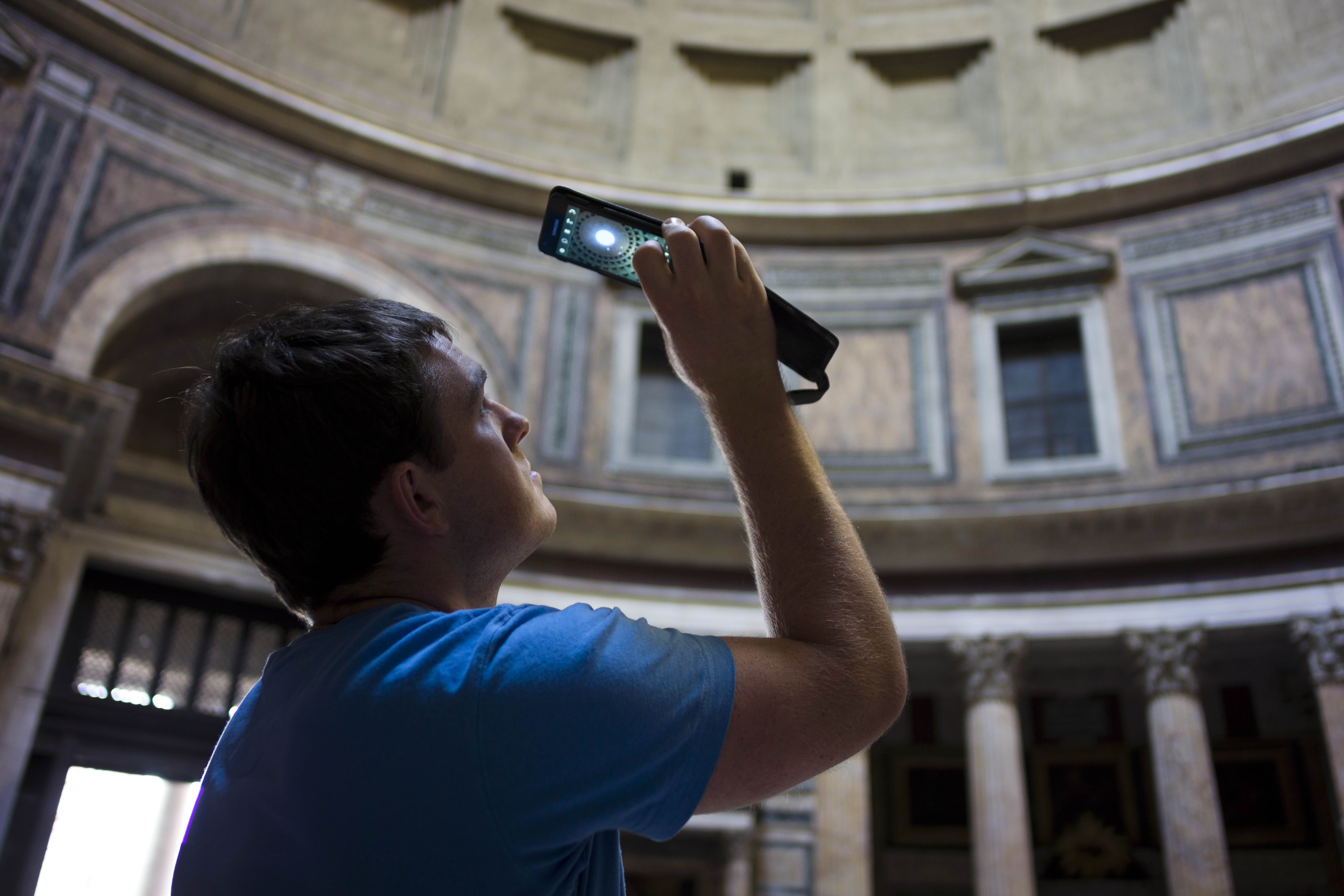 A man uses his mobile phone to take a picture of Pantheon's dome in Rome, Thursday, June 27, 2013. The Rome's Pantheon was  built under Roman Emperor Augustus between 27-25 BC to celebrate all Gods worshipped in ancient Rome and rebuilt under Emperor Adrian between 118 and 128 AD. The dome's central opening (Oculus) creates a beam of light that reflects on the temple's marble floor. ( AP Photo/Domenico Stinellis)