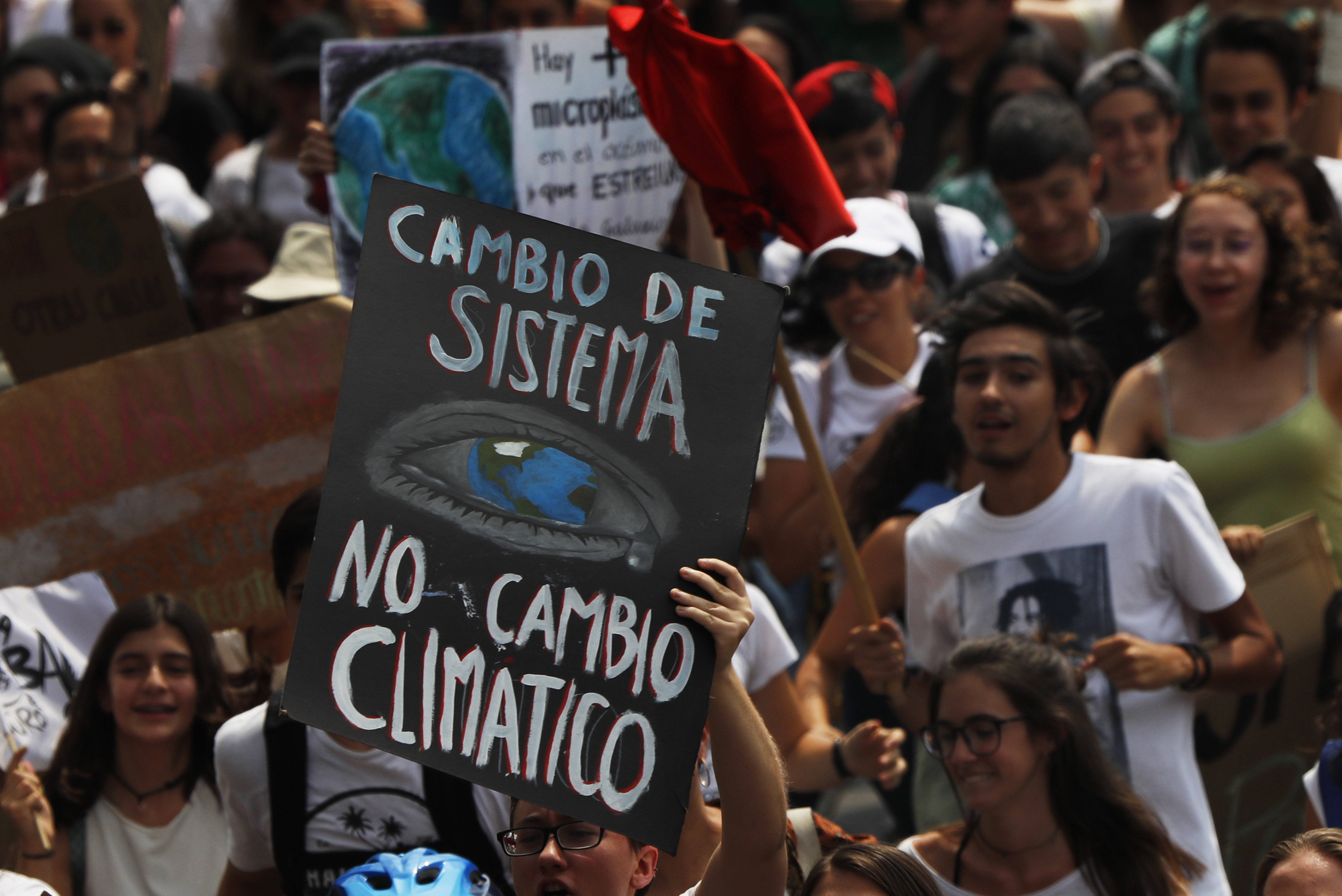 A climate demonstrator holds a sign that reads in Spanish 