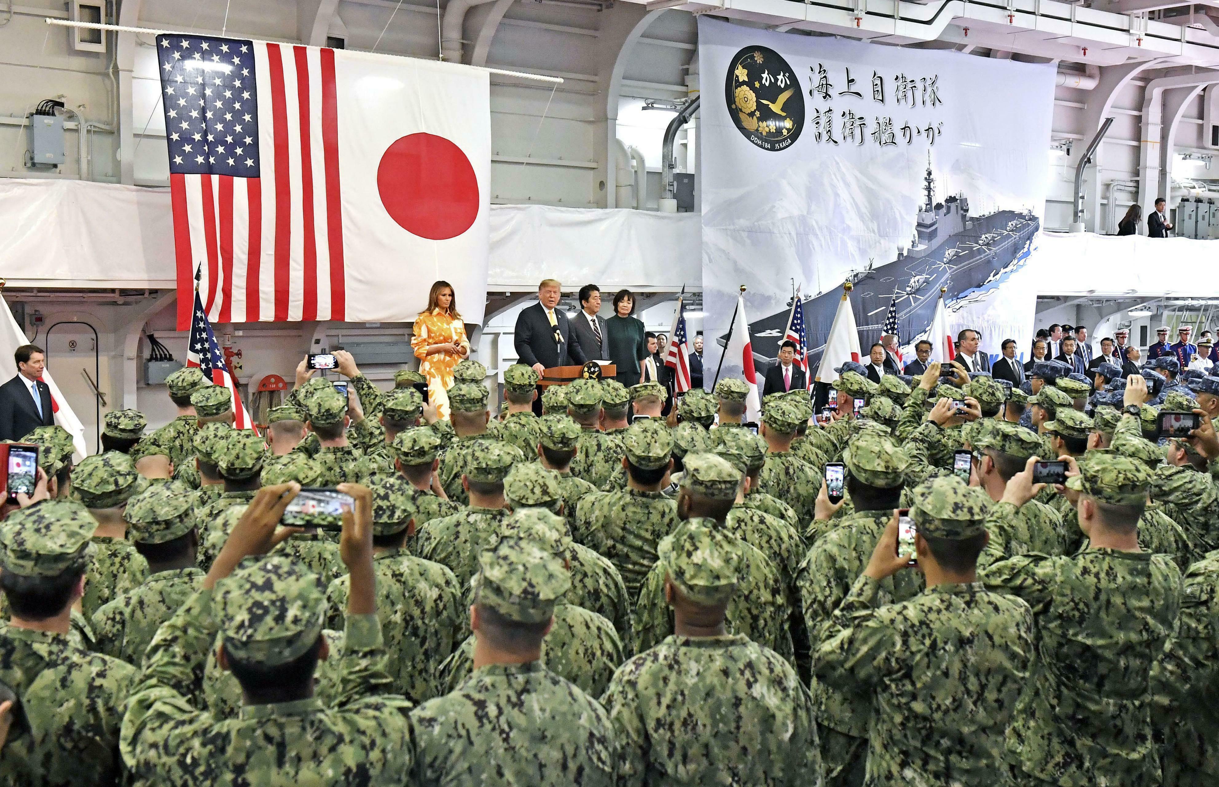U.S. President Donald Trump (C,L), standing next to Japanese Prime Minister Shinzo Abe (C,R), addresses American and Japanese troops on the Japanese Maritime Self-Defense Force's helicopter-carrying destroyer Kaga, docked at the MSDF base in Yokosuka, south of Tokyo, on May 28, 2019. (Pool photo) (Kyodo via AP Images) ==Kyodo