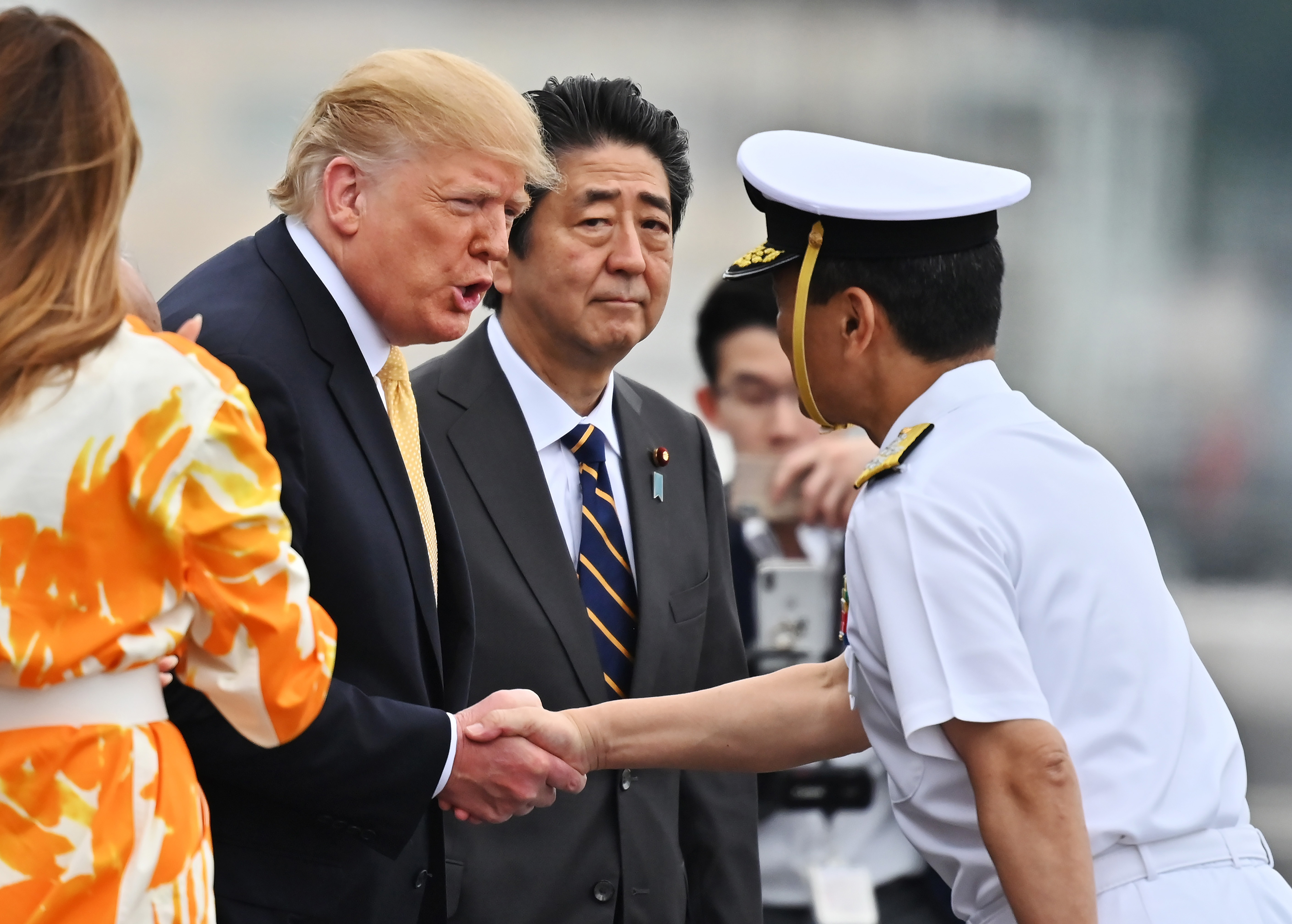 U.S. President Donald Trump, second left, shakes hands with Hideki Mizuta, right, captain of Japanese destroyer, the J.S. Kaga,  as he leaves the navy ship in Yokosuka, south of Tokyo Tuesday, May 28, 2019. (Charly Triballeau/Pool Photo via AP)