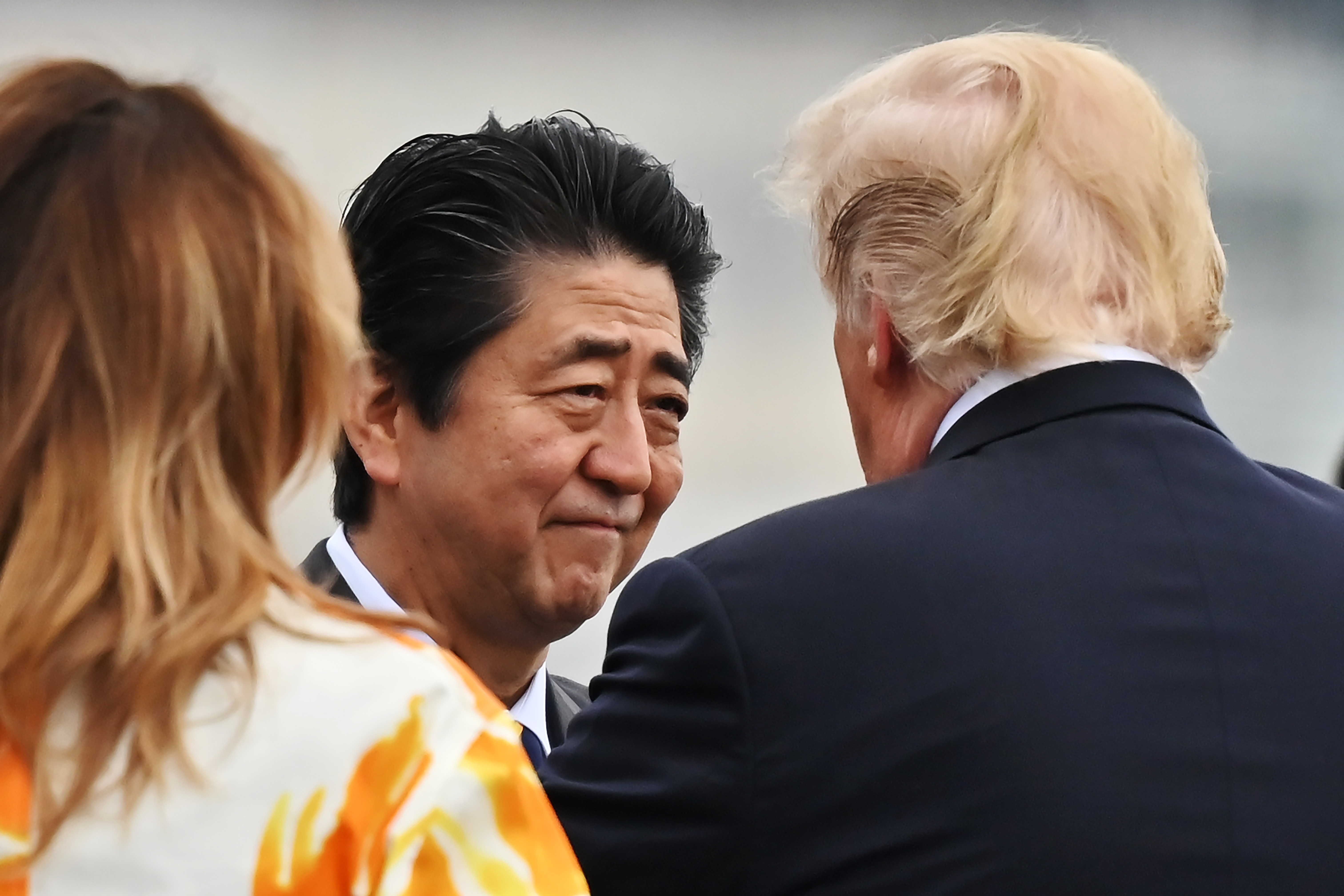 U.S. President Donald Trump, right, talks with Japanese Prime Minister Shinzo Abe, flanked by First Lady Melania Trump, left, onboard the Japanese destroyer JS Kaga, in Yokosuka, south of Tokyo Tuesday, May 28, 2019.(Charly Triballeau/Pool Photo via AP)