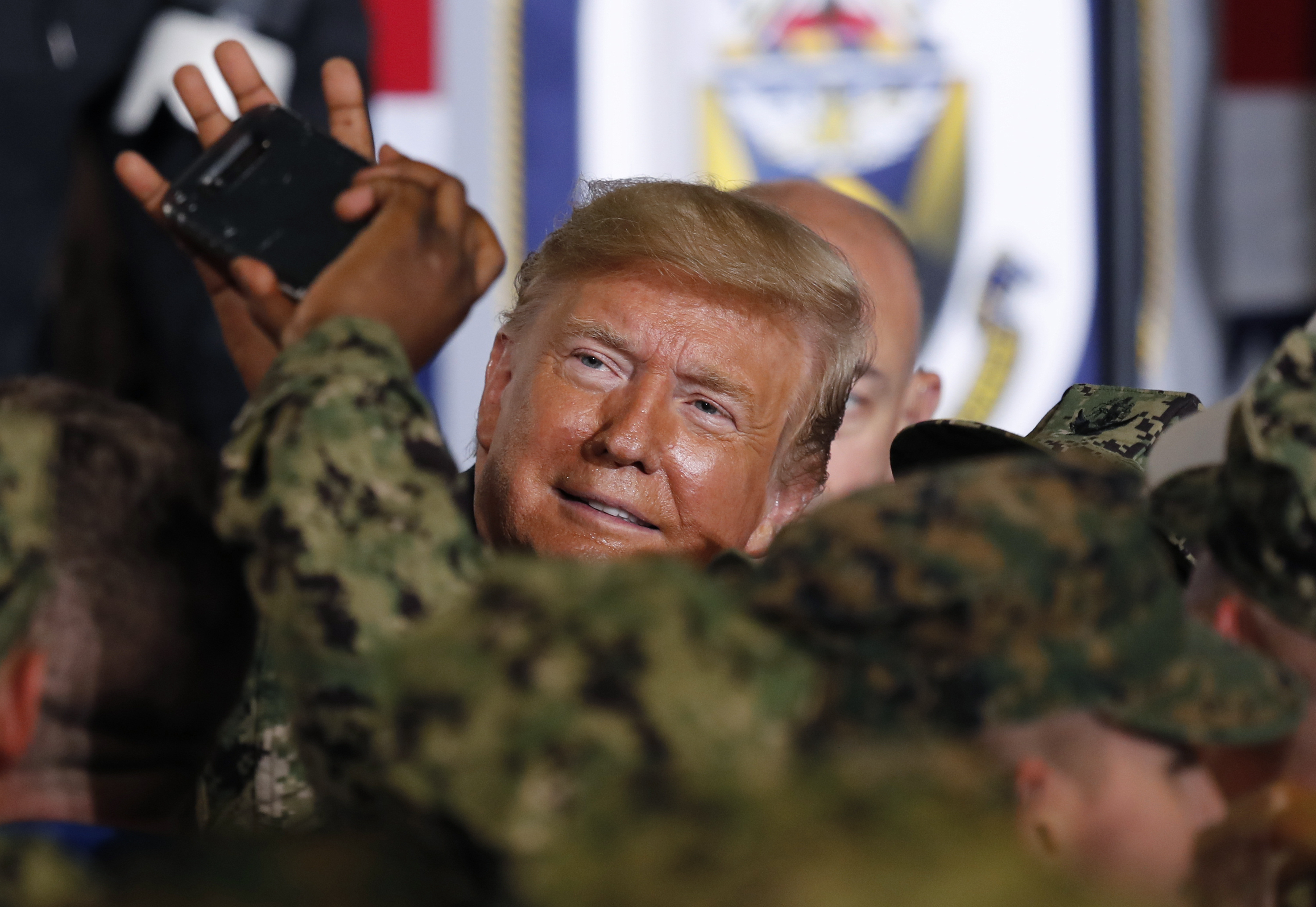 U.S. President Donald Trump takes a selfie with one of U.S. servicemen at U.S. Navy multipurpose amphibious assault ship USS Wasp at the U.S. Navy's Yokosuka base in Yokosuka, south of Tokyo Tuesday, May 28, 2019. (AP Photo/Eugene Hoshiko)