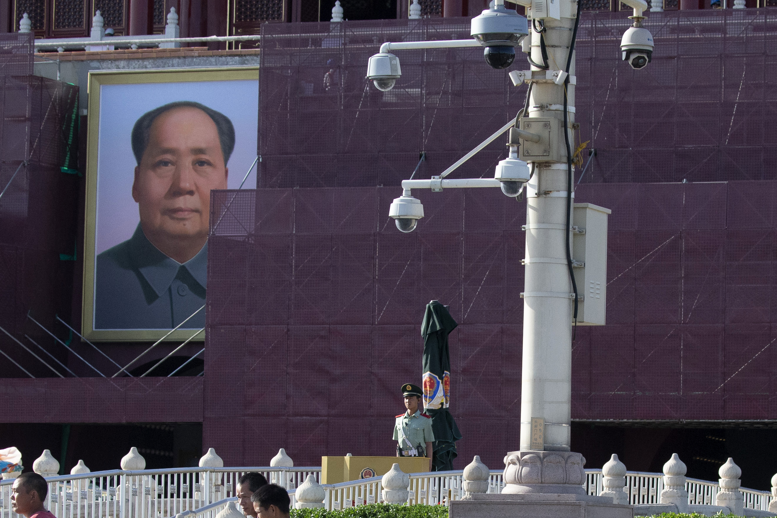 A paramilitary policeman stands on duty near security cameras in front of Mao Zedong's portrait on Tiananmen Gate in Beijing on Friday, May 31, 2019. Authorities have stepped up security around Tiananmen Square as the 30th anniversary of the bloody crackdown on pro-democracy protesters approaches for June 4. (AP Photo/Ng Han Guan)