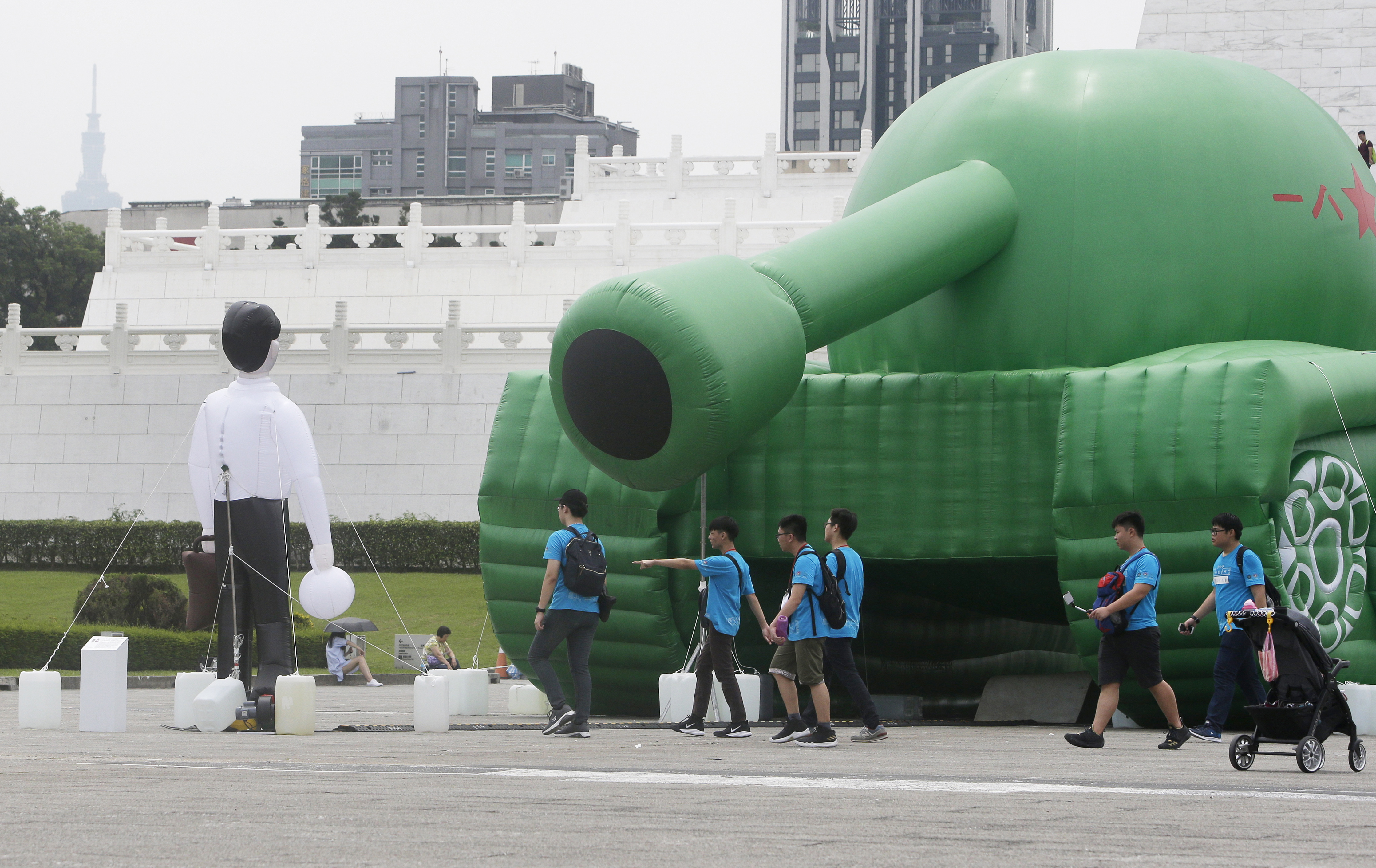 Chinese tourists walk past an inflatable tank man at the Liberty Square of Chiang Kai-shek Memorial Hall in Taipei, Taiwan, Saturday, June 1, 2019. An artist erected the inflatable display in Taiwan’s capital to mark an iconic moment in the Tiananmen Square pro-democracy protests. The larger-than-life balloon installation, which stands in front of Taipei’s famous hall, portrays a peaceful encounter between a Chinese civilian and the military tanks that contributed to a brutal shutdown of the demonstrations in Beijing on June 4, 1989. (AP Photo/Chiang Ying-ying)