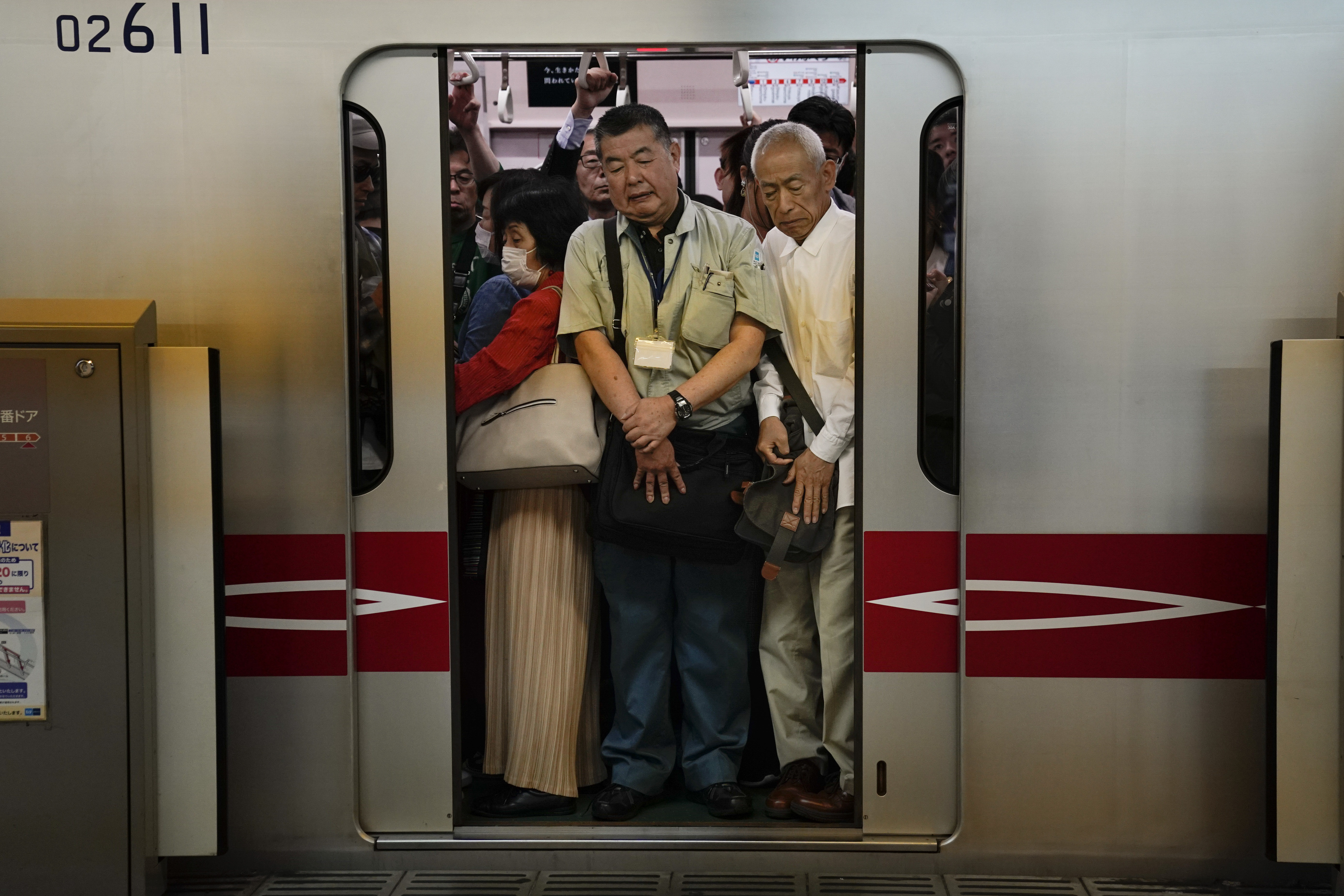 People stand pressed against each other in a commuter train as train doors close at Shinjuku Station, Saturday, May 18, 2019, in Tokyo. (AP Photo/Jae C. Hong)
