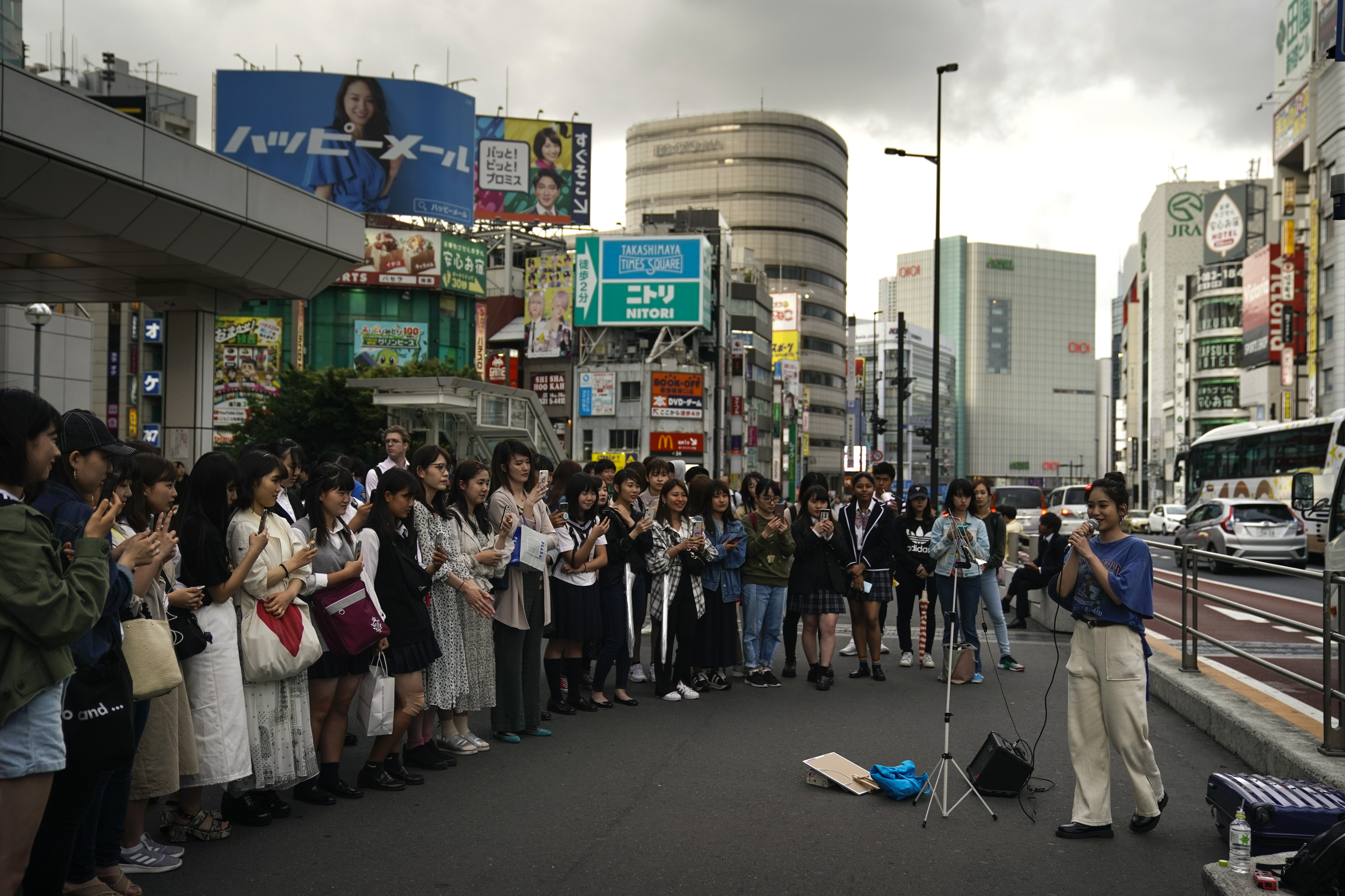 A street performer sings as she is surrounded by spectators outside the Shinjuku Station Monday, May 20, 2019, in Tokyo. (AP Photo/Jae C. Hong)