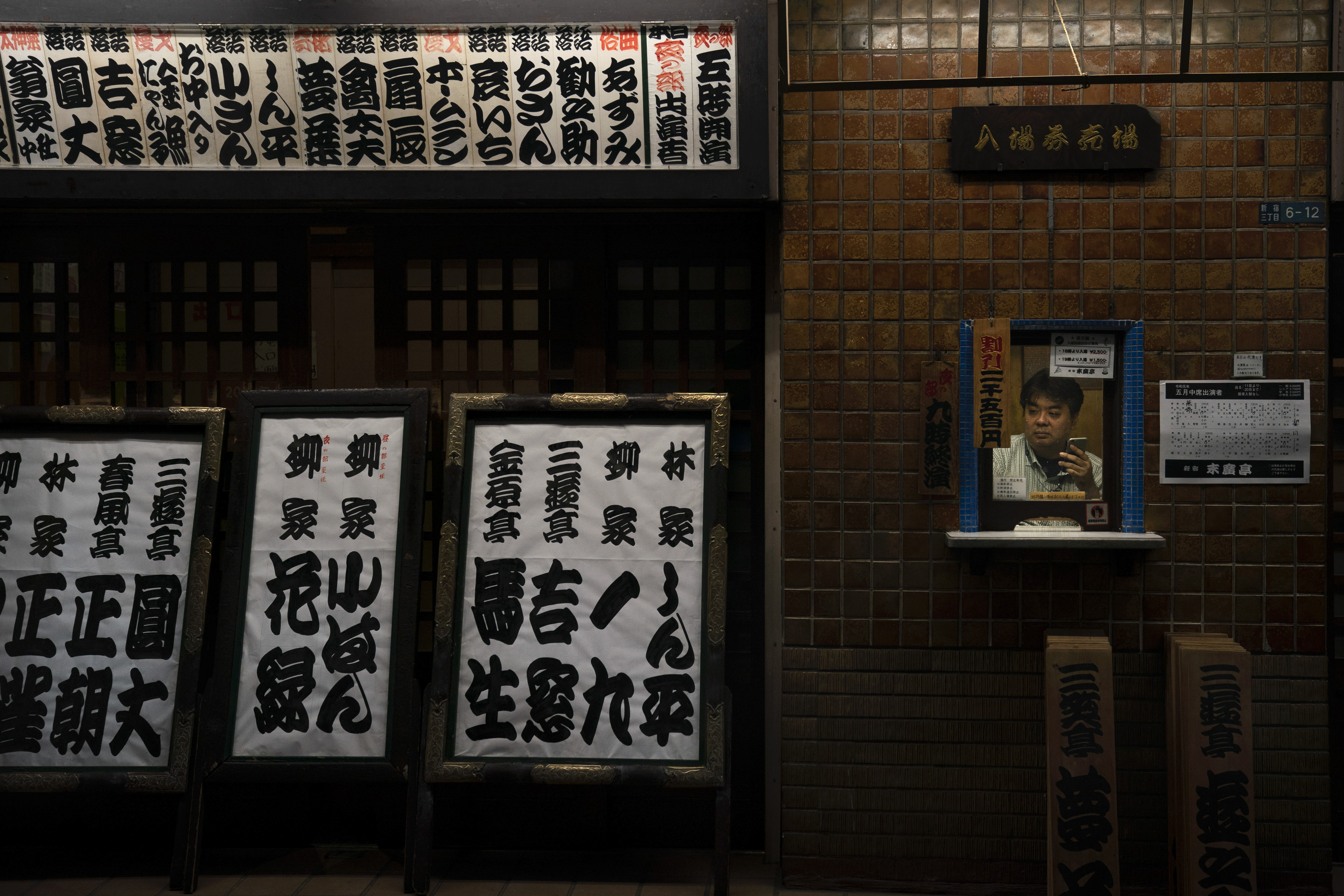 An employee sits in a ticket booth at Suehirotei yose, an entertainment hall where traditional Japanese storytelling called rakugo is performed, Monday, May 20, 2019, in Shinjuku district in Tokyo. (AP Photo/Jae C. Hong)
