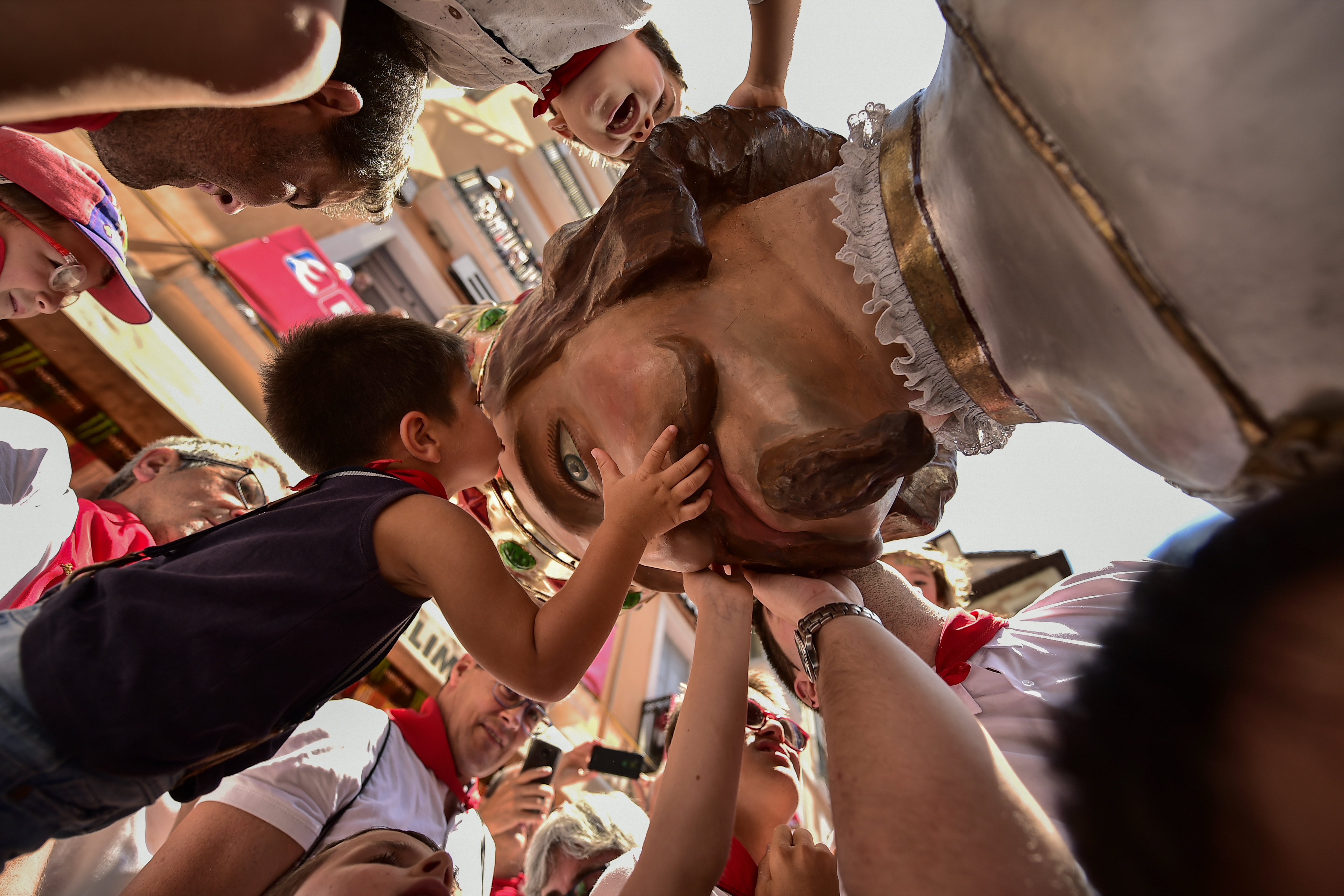 EDS NOTE : SPANISH LAW REQUIRES THAT THE FACES OF MINORS ARE MASKED IN PUBLICATIONS WITHIN SPAIN. Children say goodbye to a giant of San Fermin's Comparsa Parade at the San Fermin Festival in Pamplona, northern Spain, Sunday July 14, 2018. Revellers from around the world flock to Pamplona every year to take part in the eight days of the running of the bulls. (AP Photo/Alvaro Barrientos)