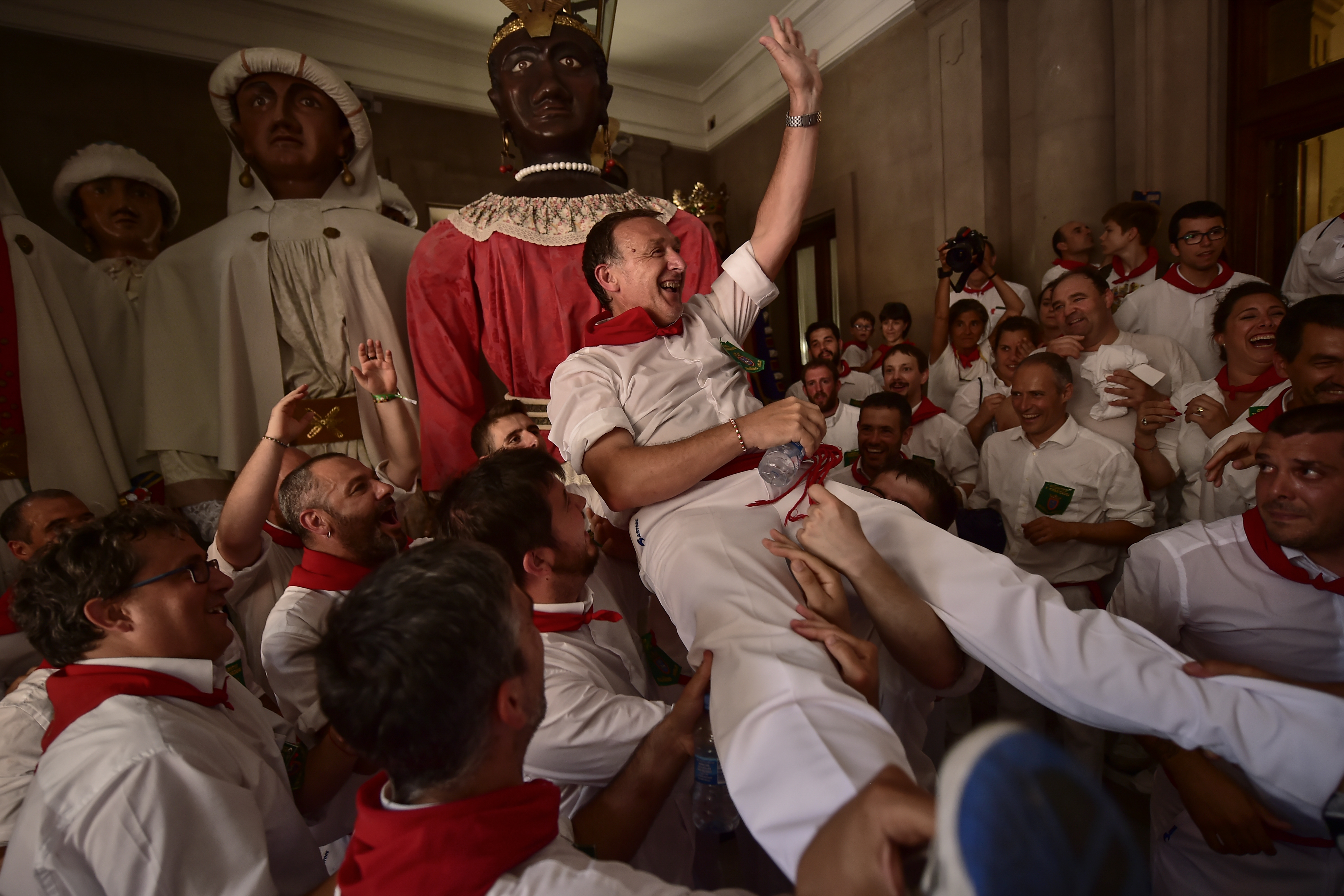 Members of San Fermin Comparsa Parade say goodbye to giants of San Fermin's Comparsa at the San Fermin Festival in Pamplona, northern Spain, Sunday July 14, 2018. Revellers from around the world flock to Pamplona every year to take part in the eight days of the running of the bulls. (AP Photo/Alvaro Barrientos)
