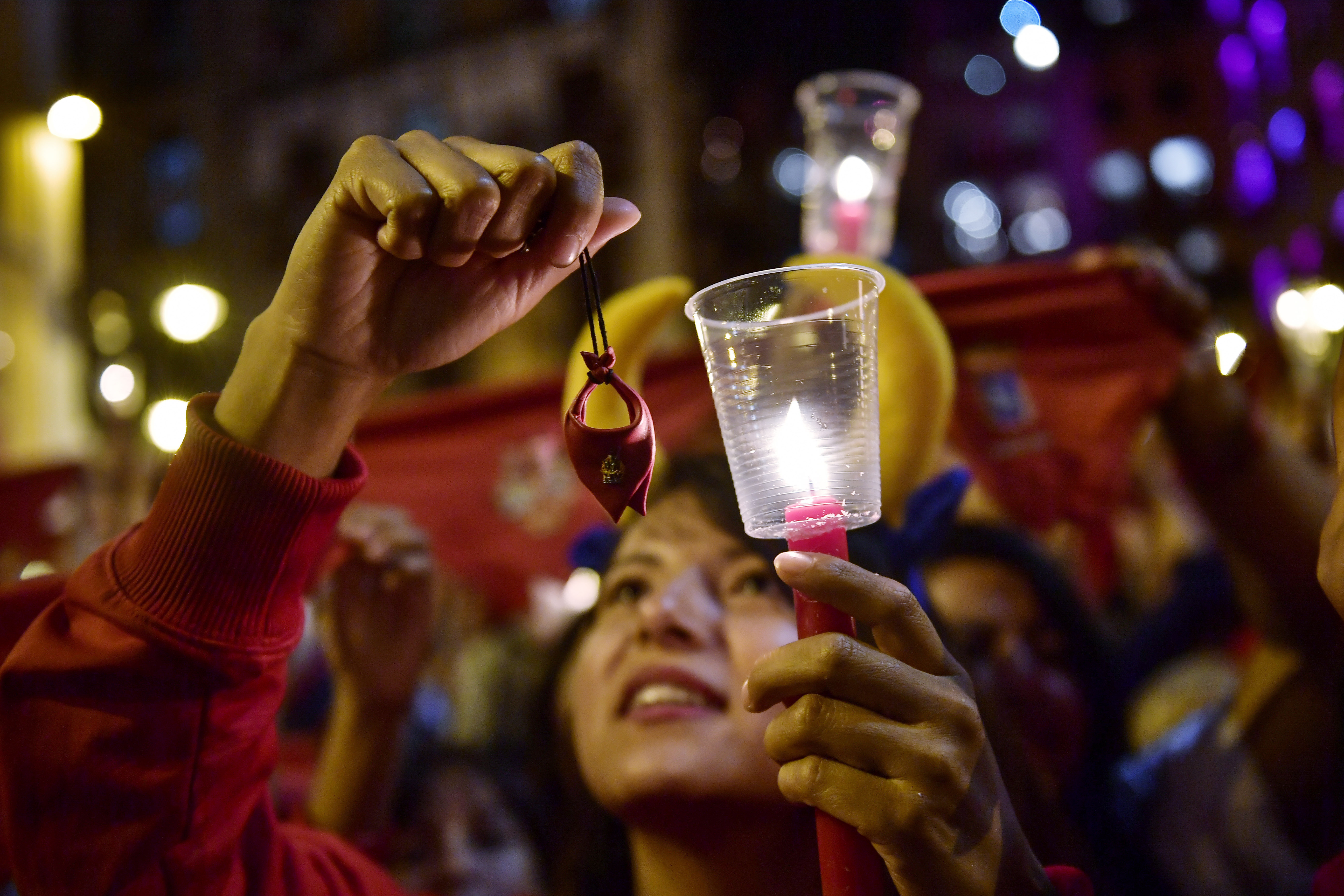 Reveler holds candles after sing a song ''Pobre de Mi'' to close nine days of the running of the bulls, music and dance at the San Fermin Festival, in Pamplona, northern Spain, Monday, July 15, 2019. (AP Photo/Alvaro Barrientos)