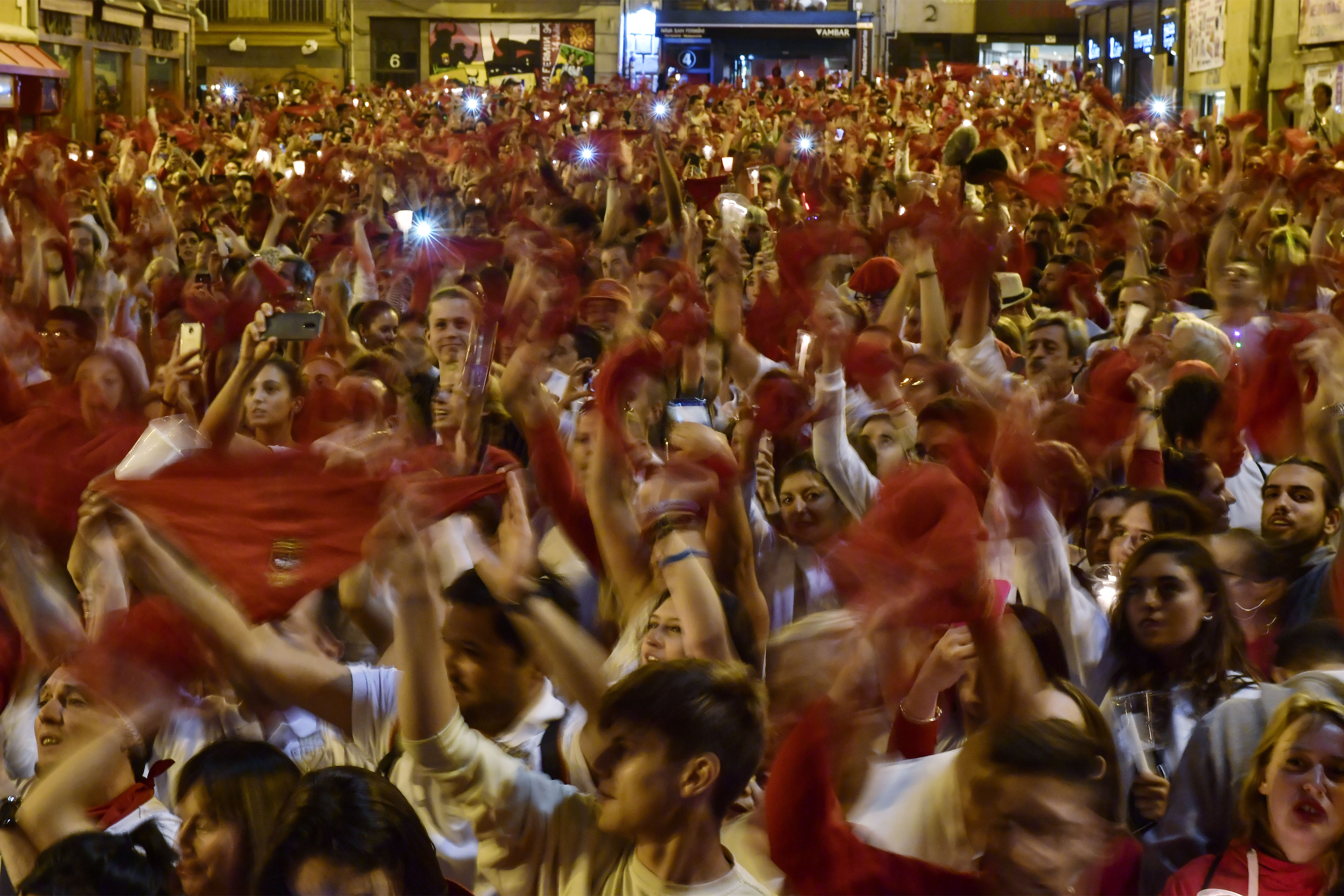Revelers hold candles and red kerchief after singing a song ''Pobre de Mi'' to close nine days of the running of the bulls, music and dance at the San Fermin Festival, in Pamplona, northern Spain, Monday, July 15, 2019. (AP Photo/Alvaro Barrientos)