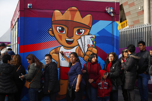 People stand in line to enter the National stadium prior to the Opening Ceremony for the Pan American Games in Lima, Peru, Friday, July 26, 2019. (AP Photo/Rebecca Blackwell)