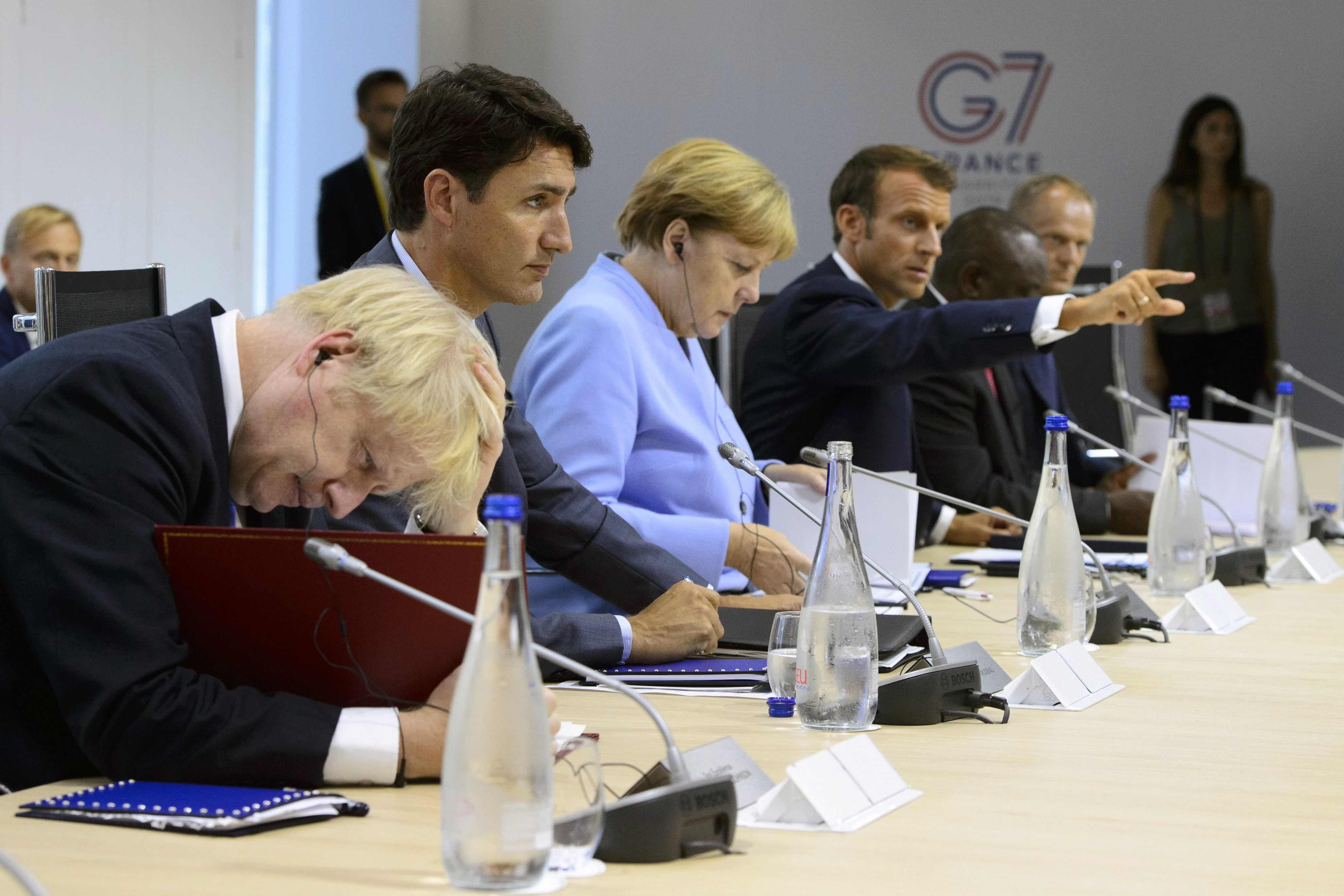 Canadian Prime Minister Justin Trudeau, second from left, sits between British Prime Minister Boris Johnson, left, and German Chancellor Angela Merkel as they take part in a meeting at the G7 Summit in Biarritz, France,  Monday, Aug. 26, 2019. Gesturing at right is French President Emmanuel Macron. (Sean Kilpatrick/The Canadian Press via AP)